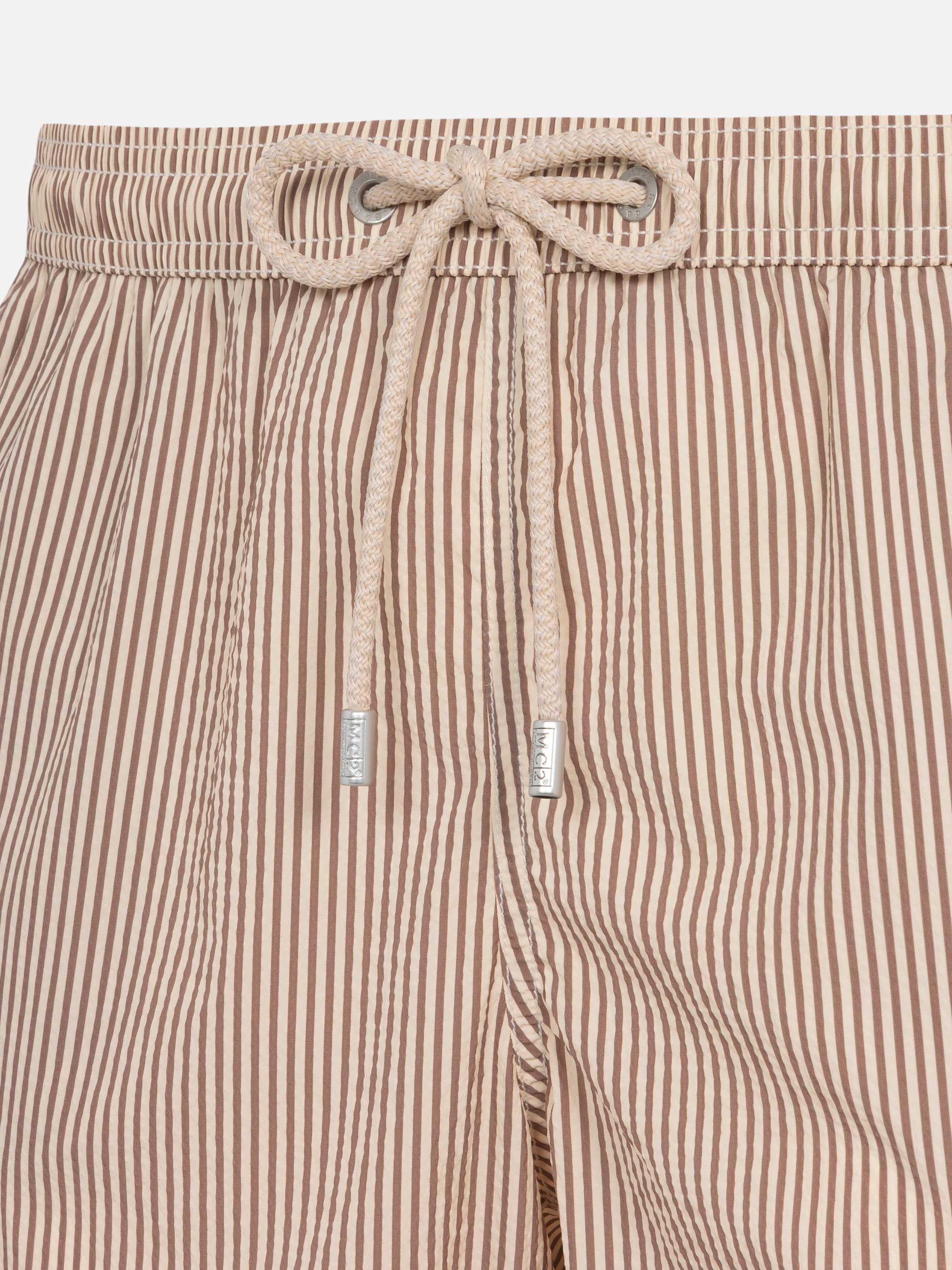 Terno Patmos Classic Lightweight em tecido seersucker listrado bege.