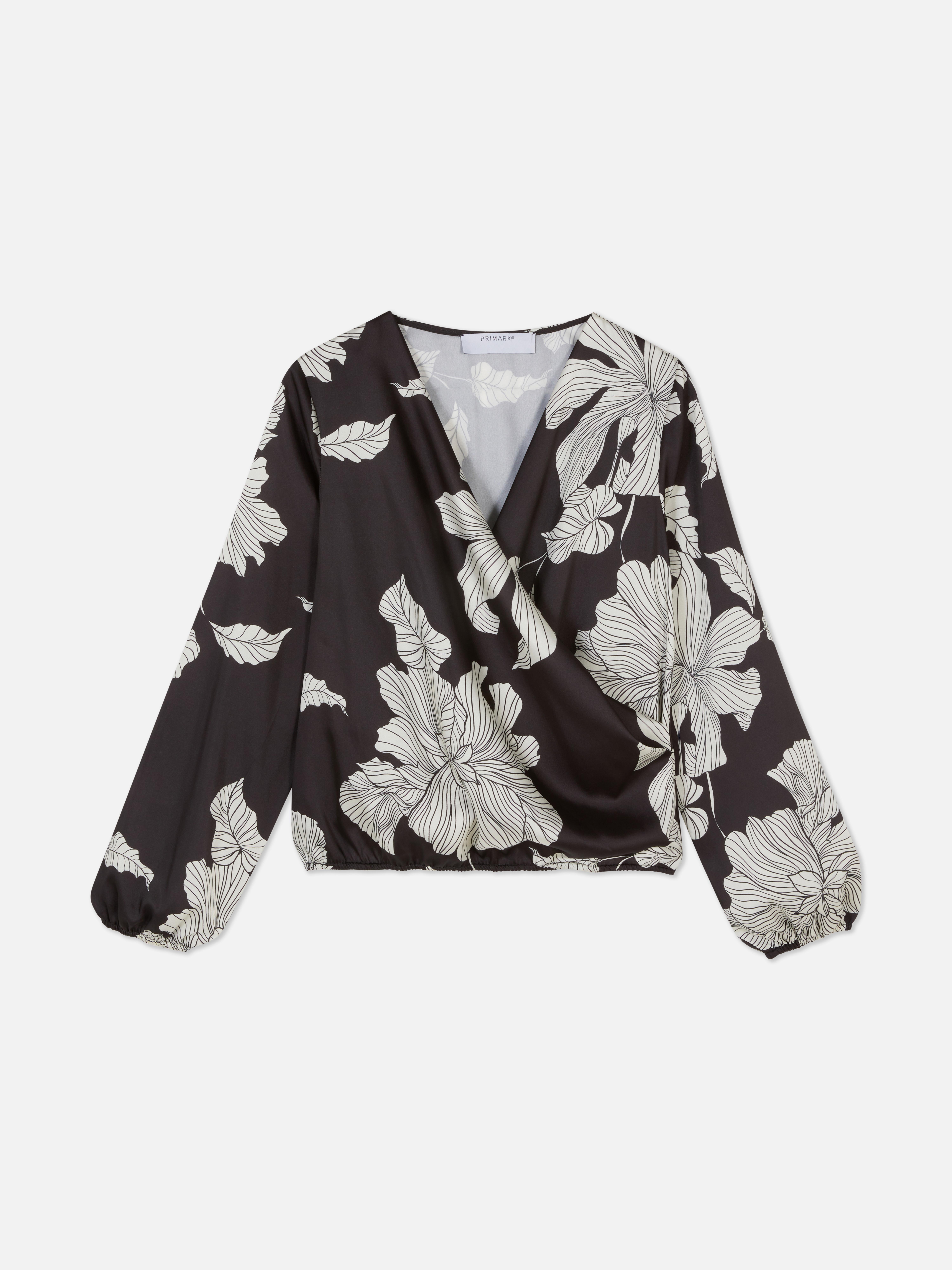 Bluză înfășurată asortată cu imprimeu floral. O bluză înfășurată cu mâneci voluminoase și imprimeu floral.