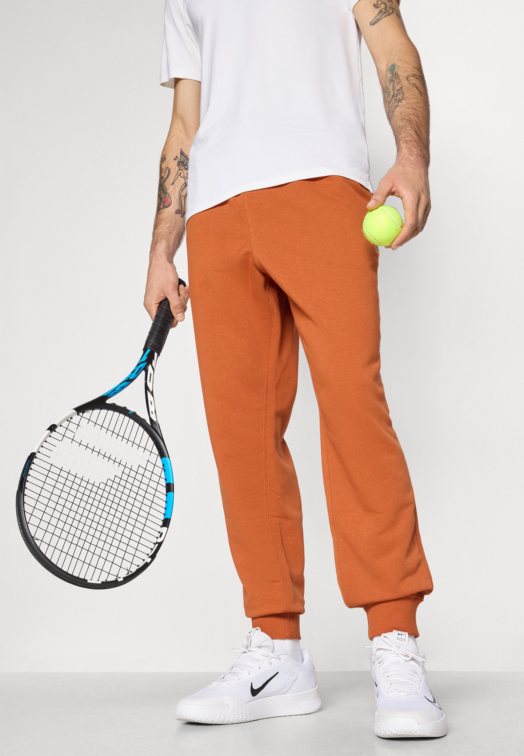 Pantaloni da jogging Nike Performance NIKECOURT HERITAGE - Pantaloni da tuta - ruggine scuro