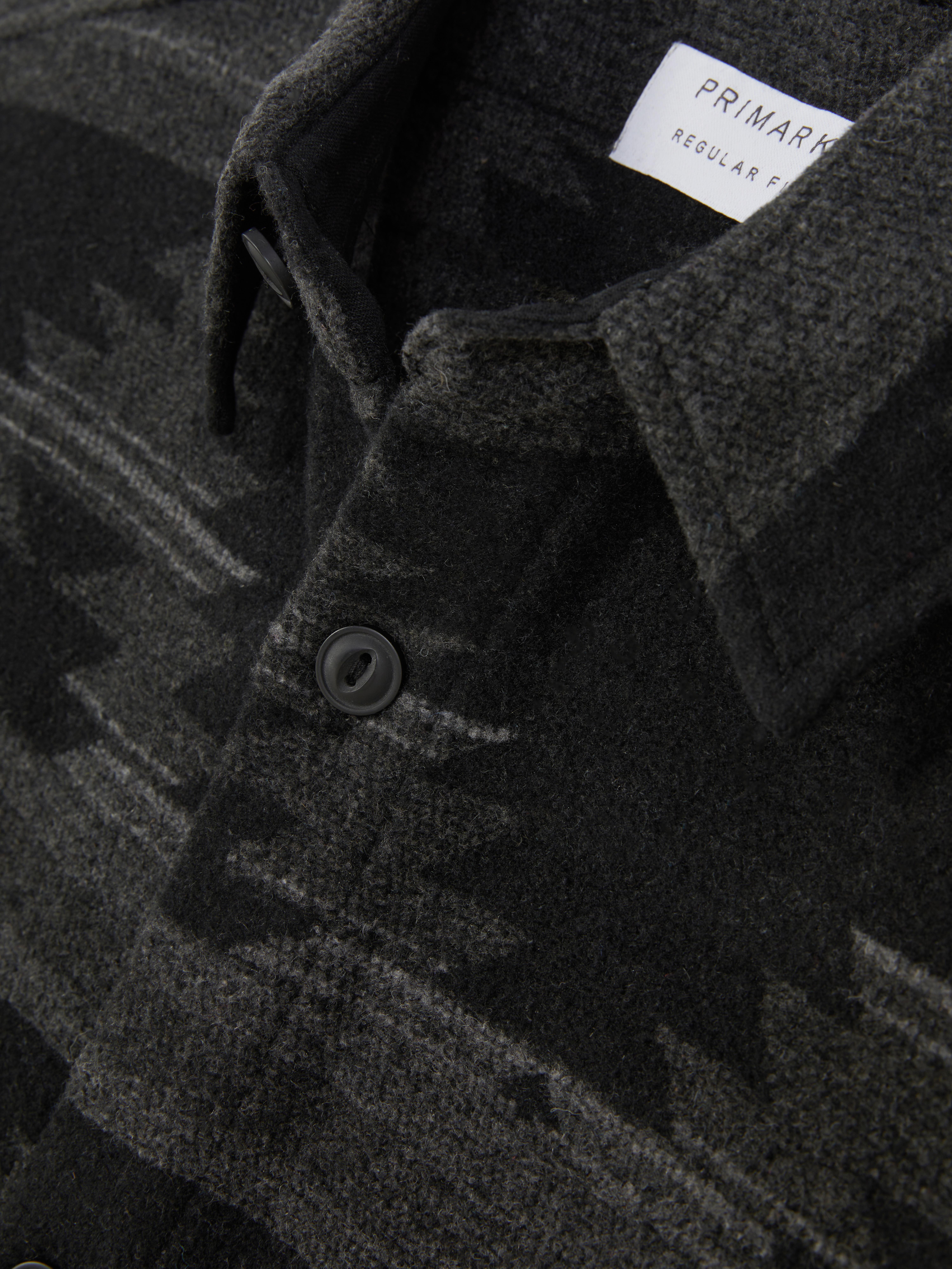 Tricou cu model geometric. Un tricou casual cu guler, două buzunare la piept și un model geometric integral.
