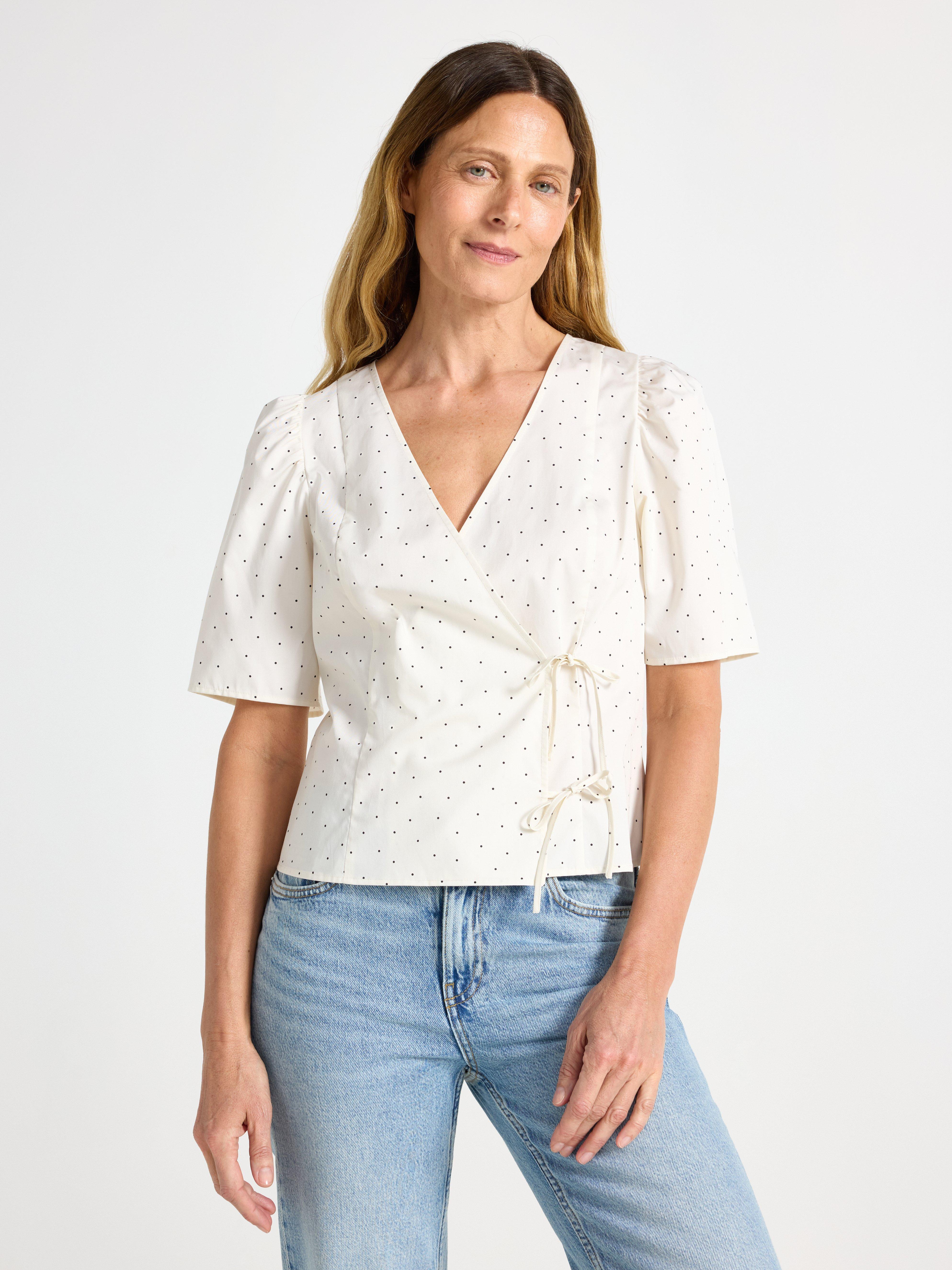 Blusa con diseño cruzado, color blanco claro.