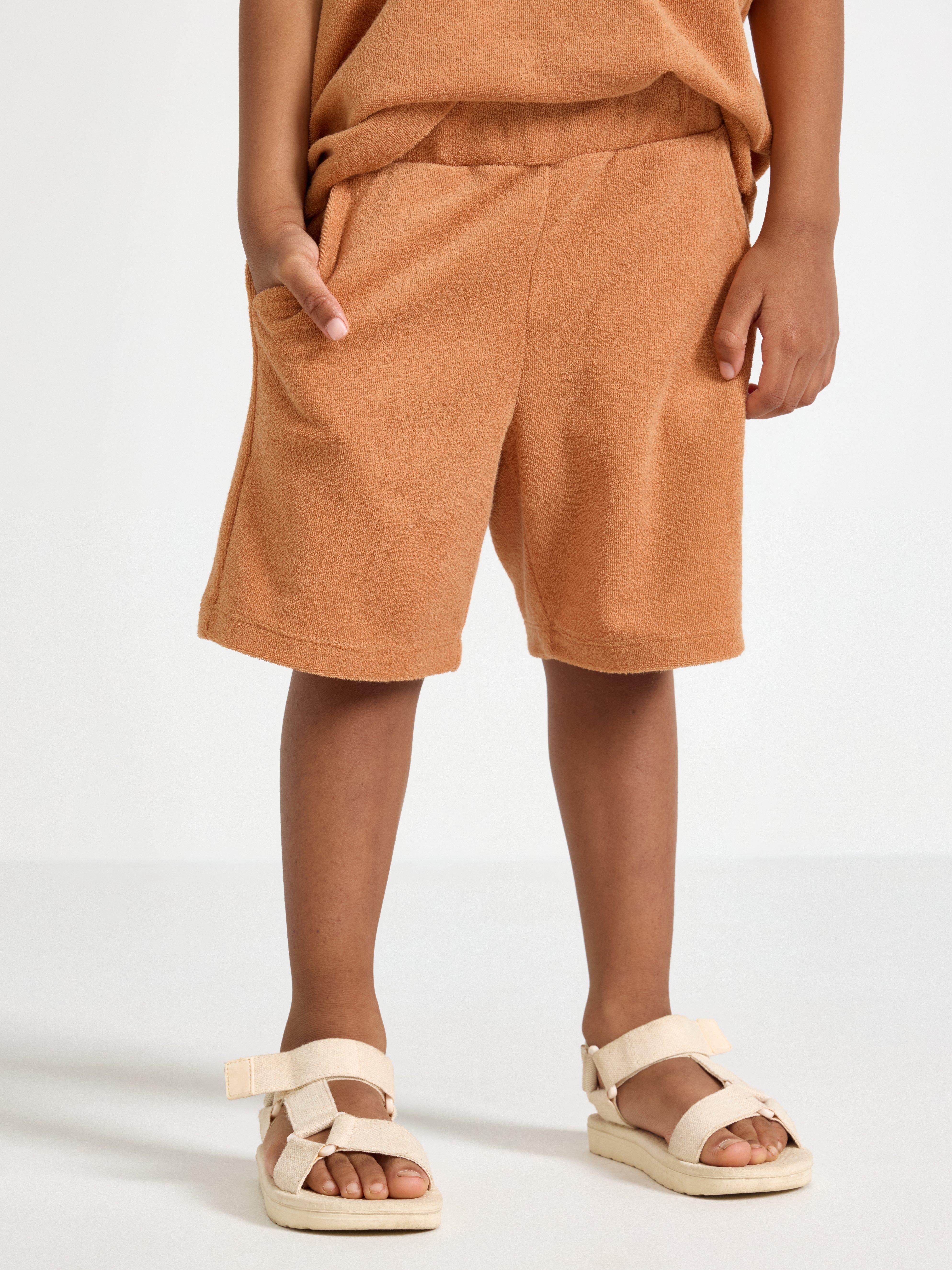 Pantalones cortos de color beige oscuro desgastado