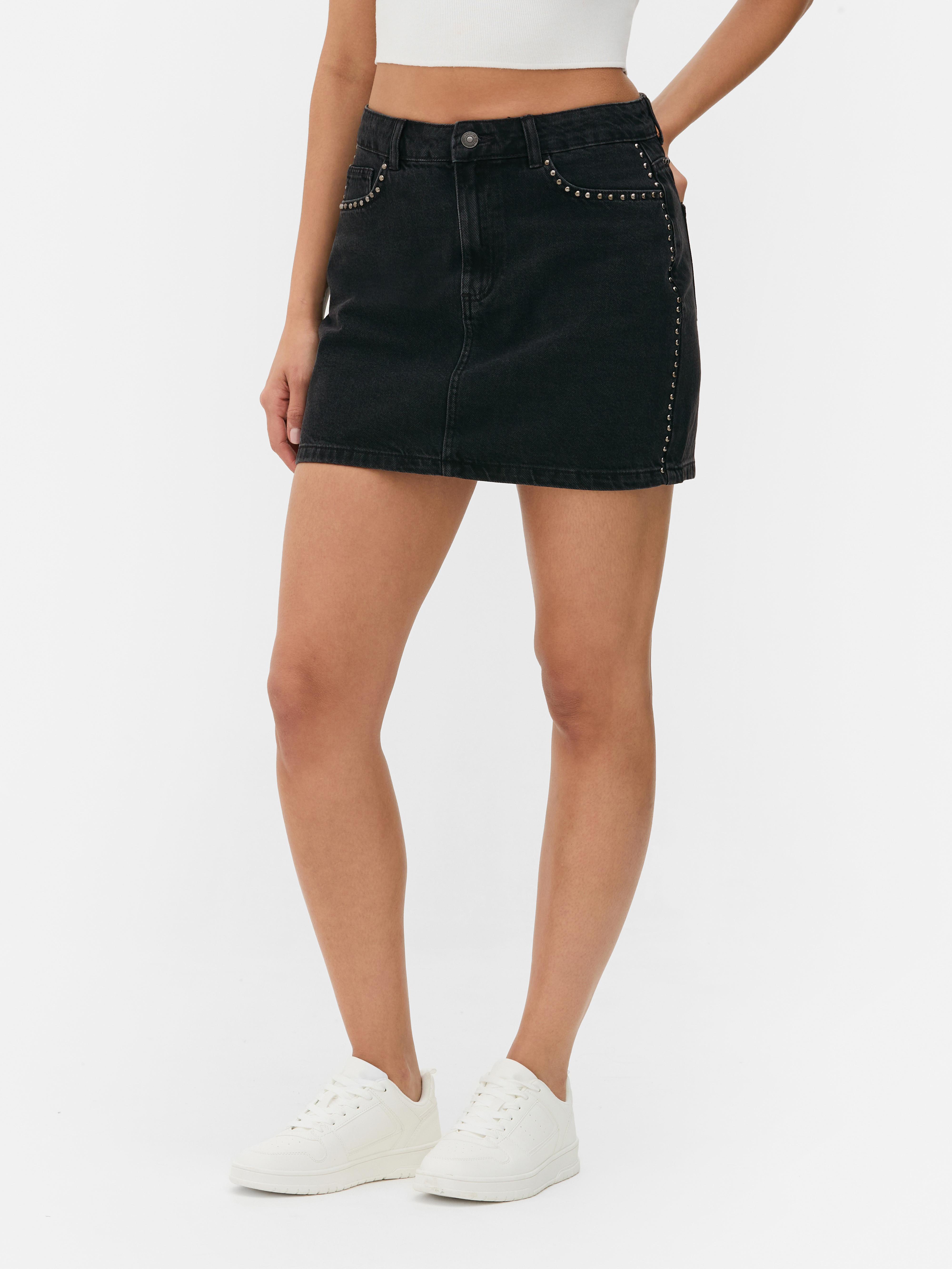 Fustă mini din denim cu ținte. Această fustă mini are cinci buzunare, găici pentru curea și fermoar.