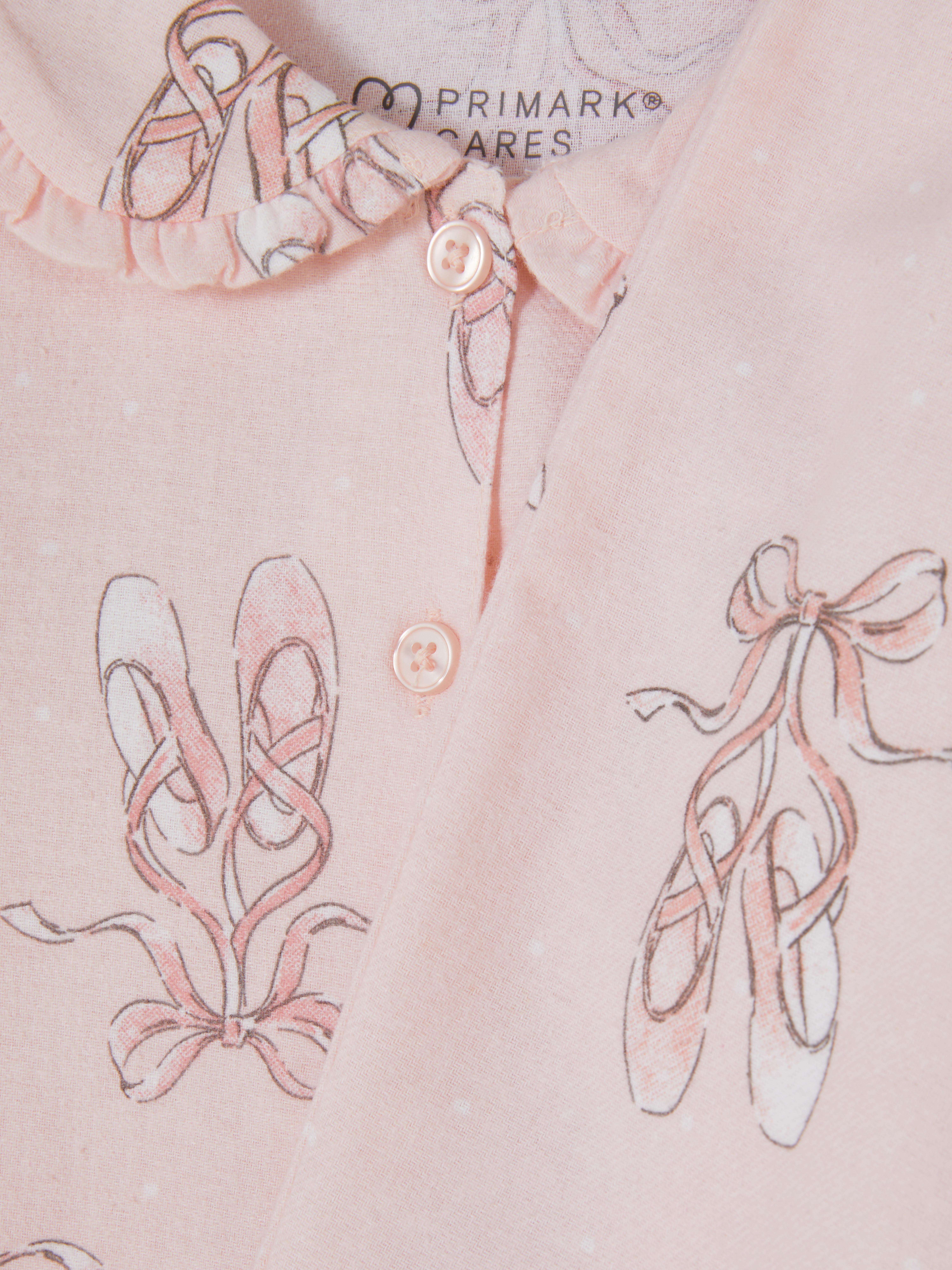 Pyjama mit Ballettschuh-Motiv. Ein Pyjama mit Oberteil mit Kragen und langer Hose mit Ballettschuh-Muster.