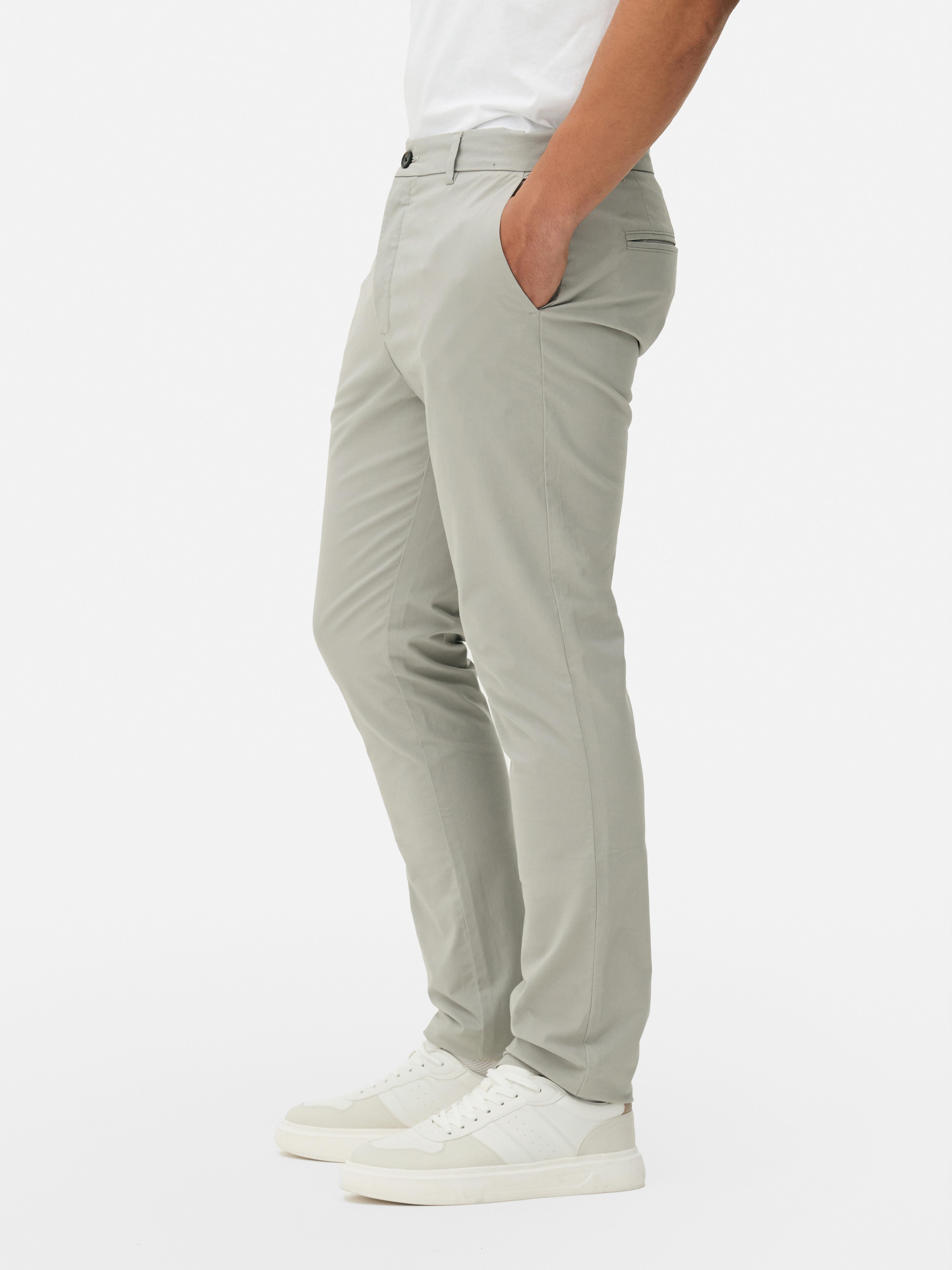 Pantaloni chino elastici, mulați. Pantaloni chino mulați, confecționați în principal din bumbac și cu buzunare laterale.
