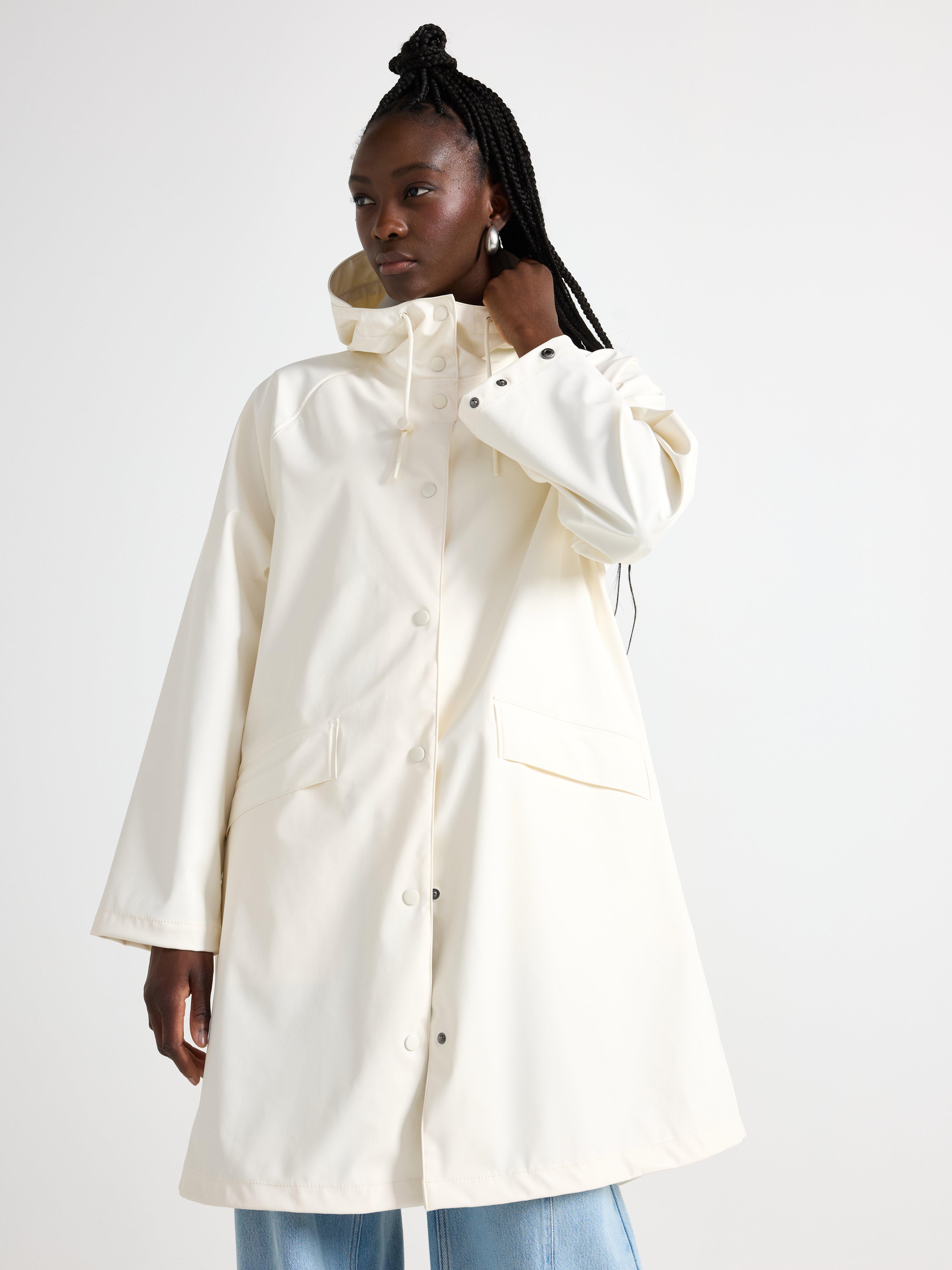 Chaqueta impermeable con capucha color blanco roto.