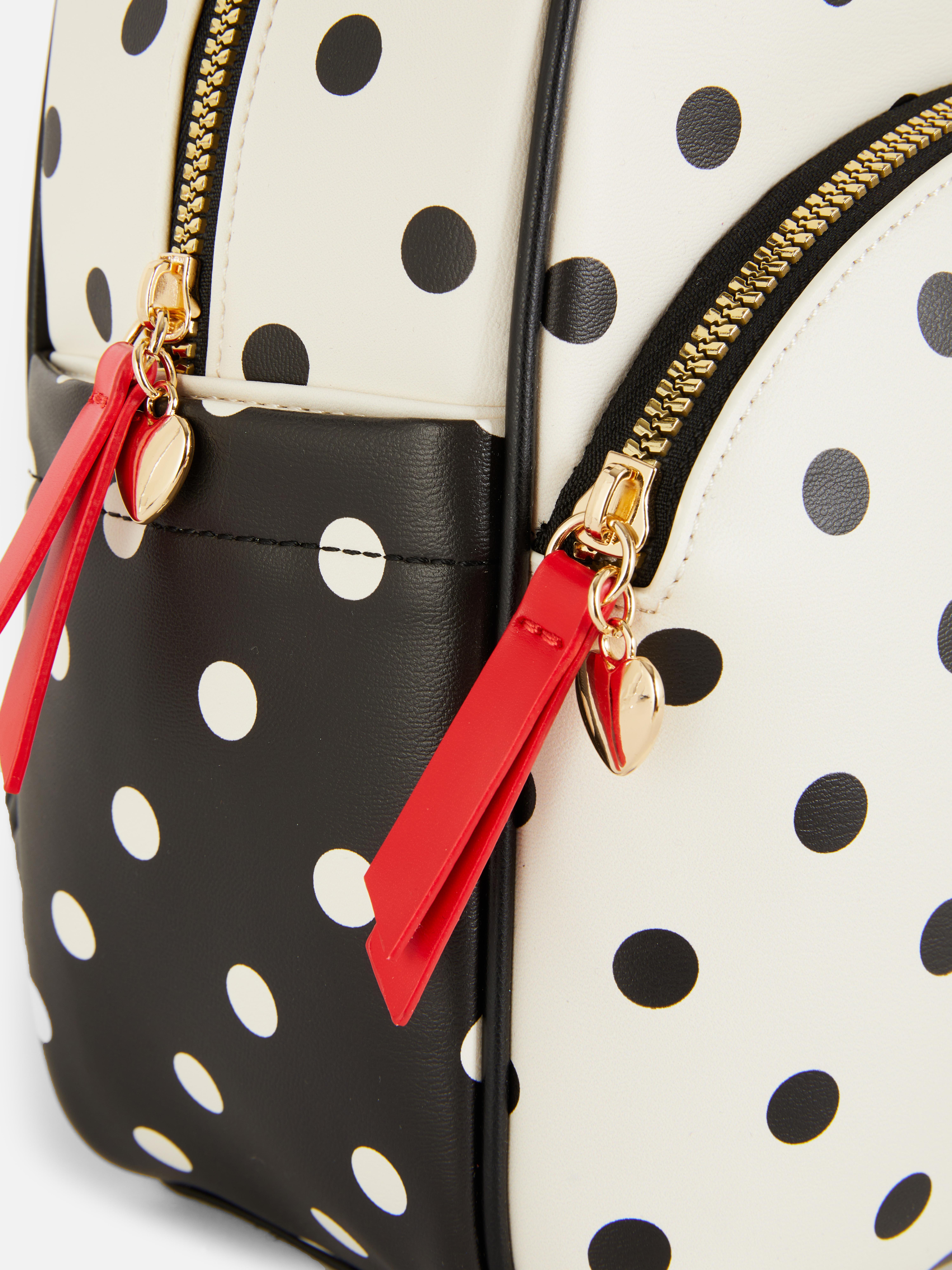 Disney Minnie Mouse Polka Dot Rucksack: Ein Rucksack aus Kunstleder mit Vordertasche, verstellbaren Schultergurten und Reißverschluss oben.