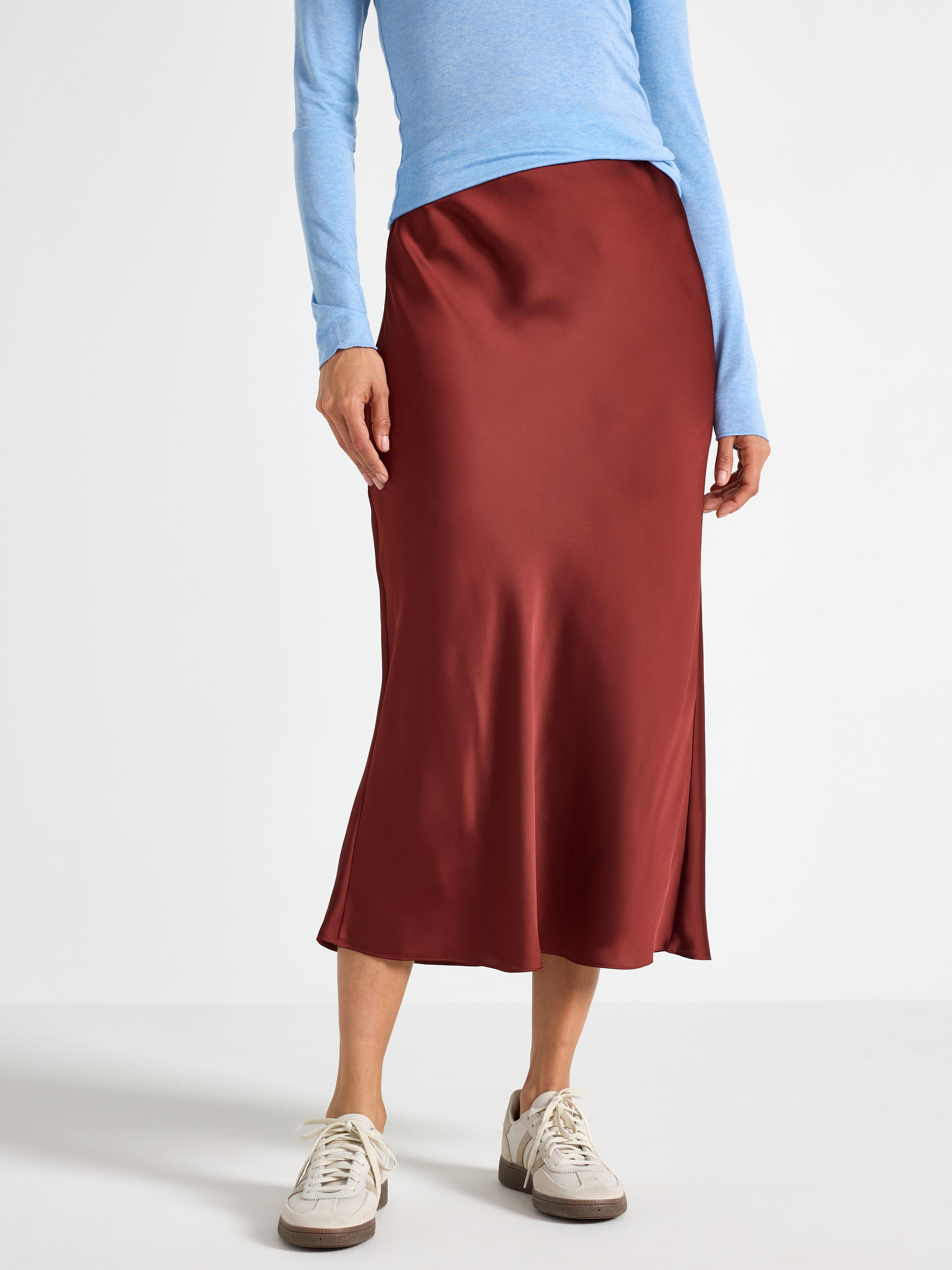 Falda midi de satén color rojo oscuro empolvado.