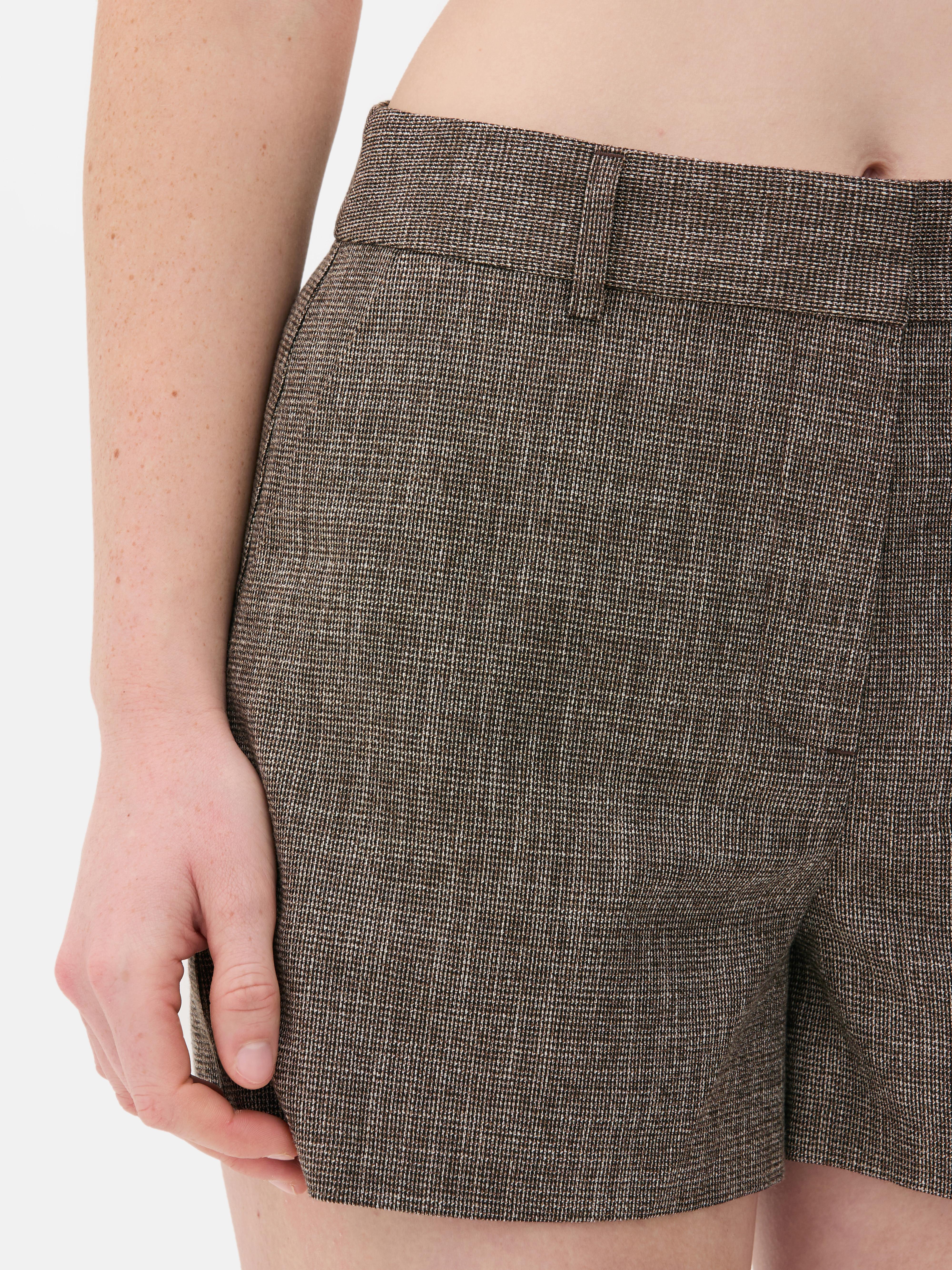 Pantaloni scurți texturați, mulați. Pantaloni scurți texturați cu găici pentru curea, buzunare și închidere cu cârlig în față.