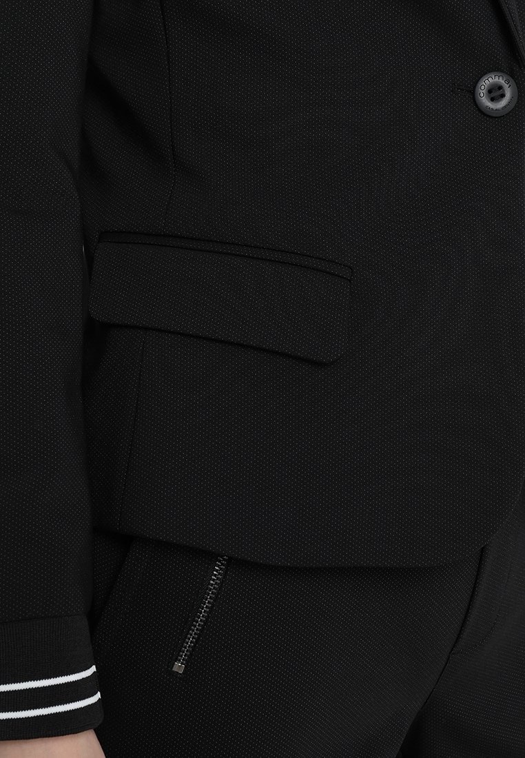 Blazer noir à l'identité décontractée.