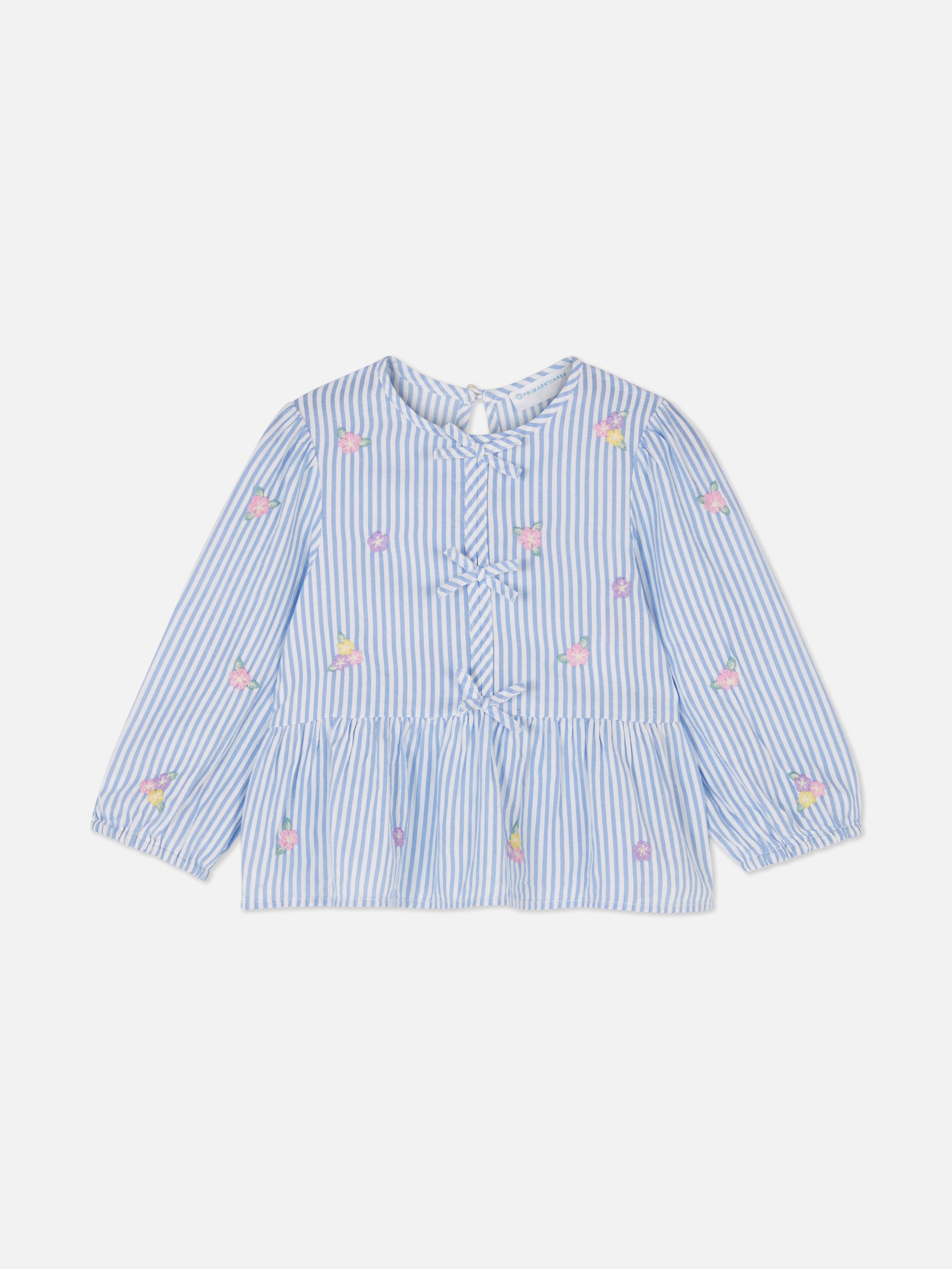 Bluse mit Blumenmuster und Schleife. Eine Bluse mit Schleife, langen Ärmeln, Blumenstickerei und einem Schlüssellochverschluss am Rücken.