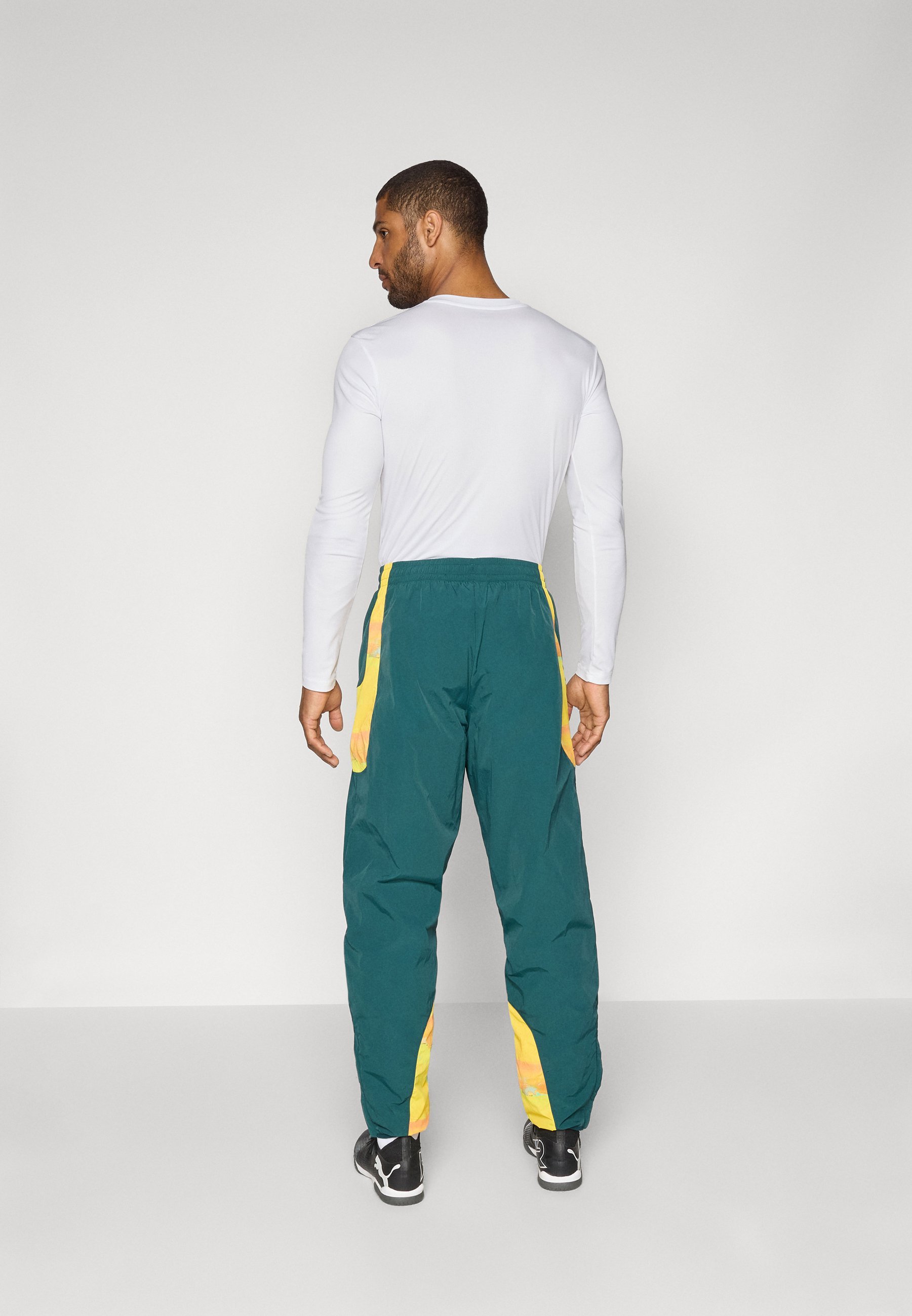 Pantaloni da viaggio Puma KIDSUPER MAMELODI SUNDOWNS FC - Abbigliamento da club - verde terreno/giallo pelo