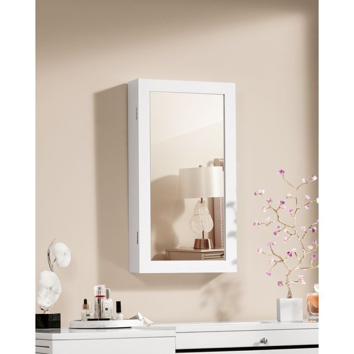 Joyero de pared con cerradura, espejo, superficie blanca y revestimiento negro.