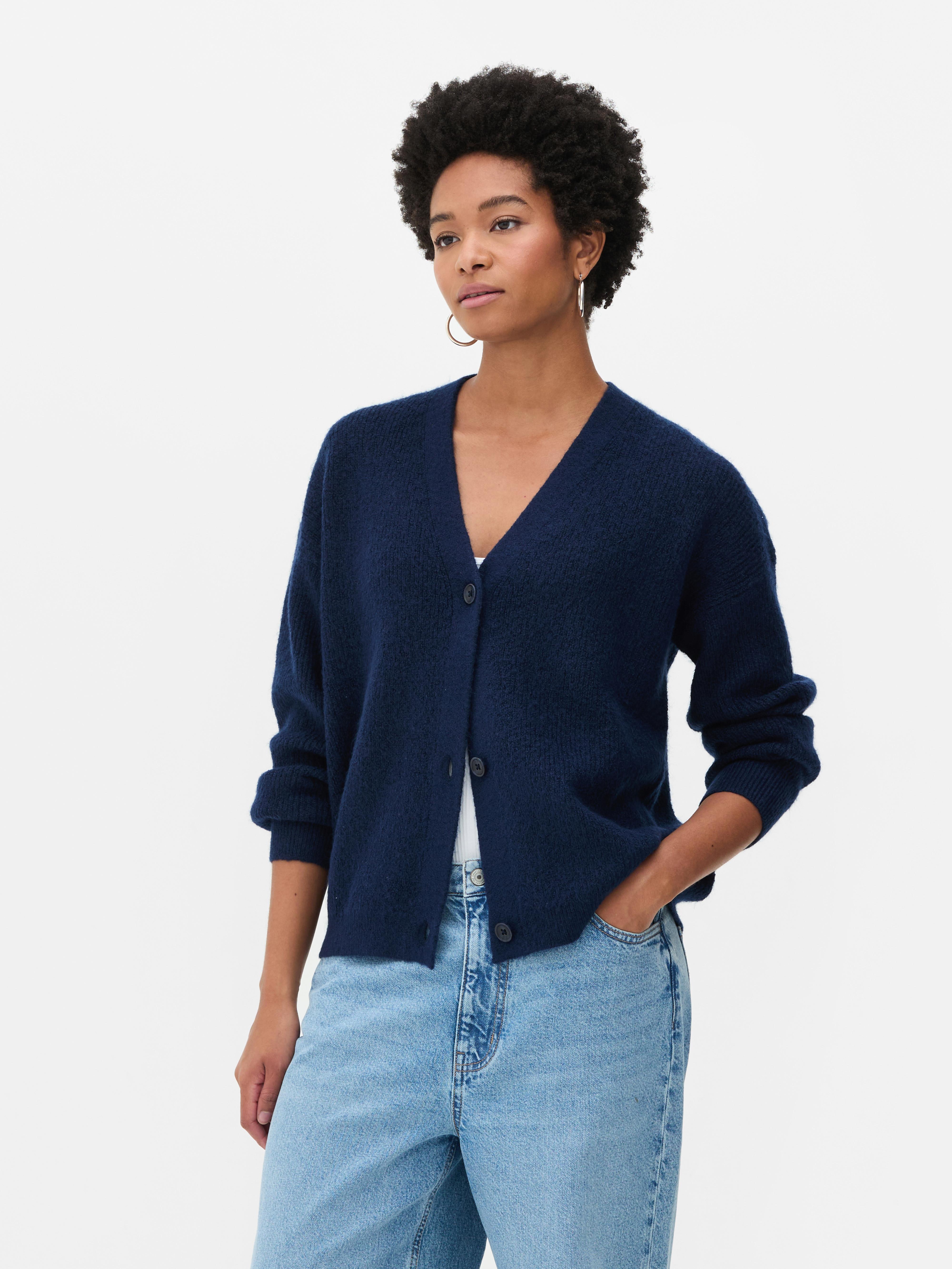 Cardigan cu decolteu în V și croială lejeră. Acest cardigan cu nasturi, croială lejeră și umeri căzuți este un clasic elegant.