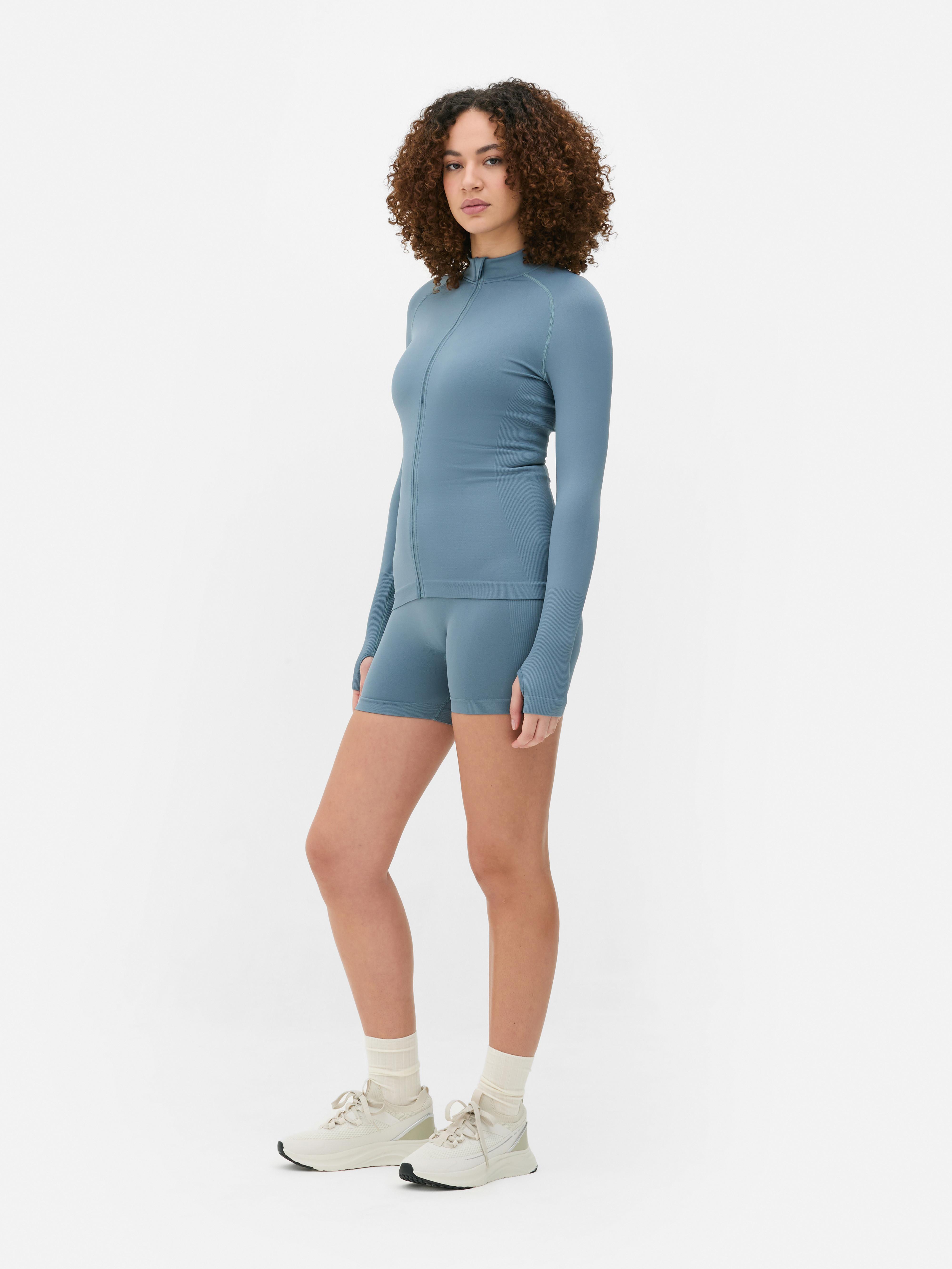 Sømløs sportsjakke med glidelås En sporty jakke med sømløst design, ståkrage og glidelås foran.