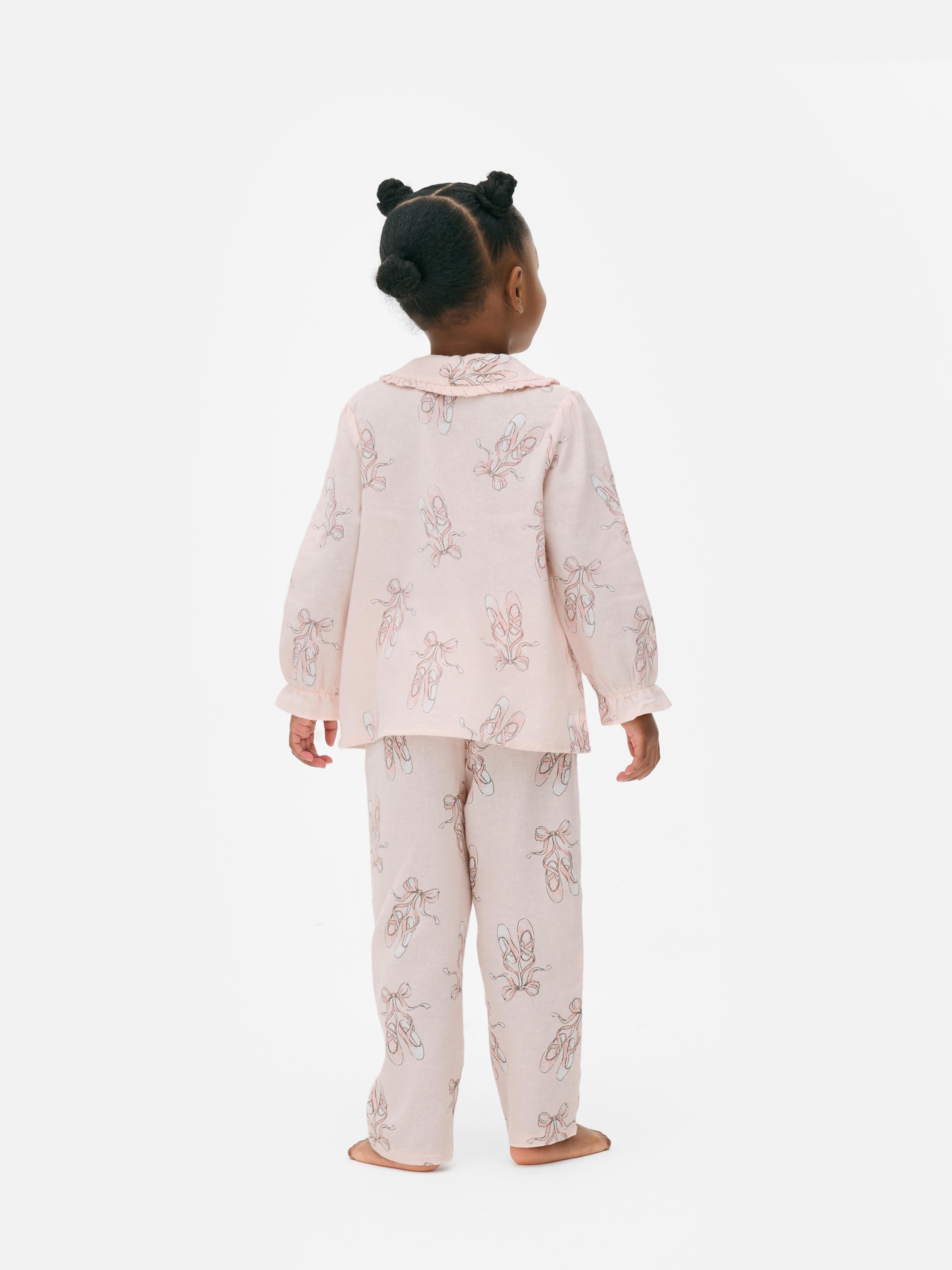 Pyjama mit Ballettschuh-Motiv. Ein Pyjama mit Oberteil mit Kragen und langer Hose mit Ballettschuh-Muster.