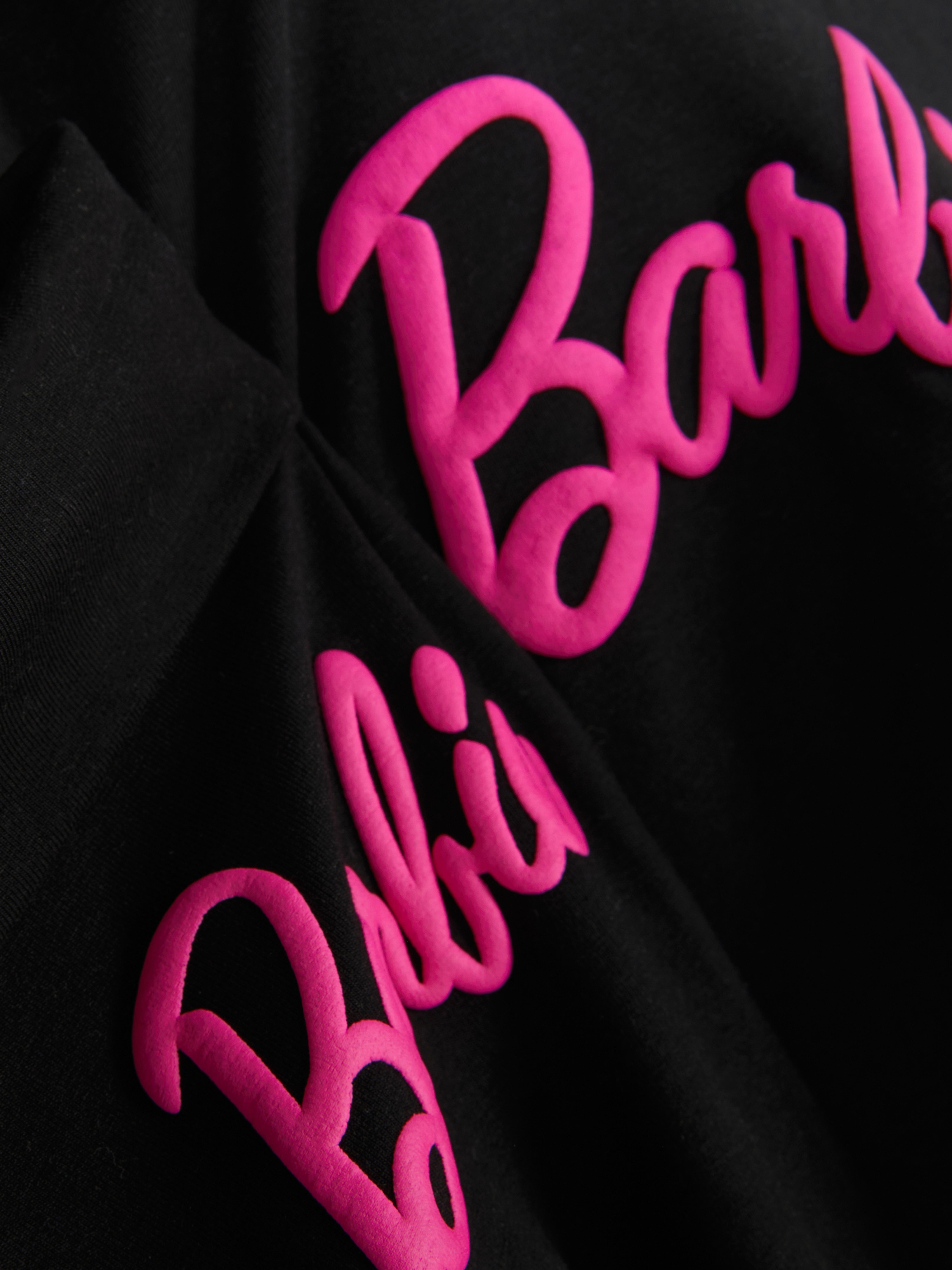 Top cu mânecă lungă Barbie și colanți evazați. Un top cu mânecă lungă asortat și colanți evazați cu imprimeu Barbie.