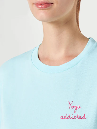 Dames katoenen T-shirt met geborduurde tekst 'yoga addict'.