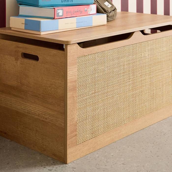 Baúl de juguetes infantil con decoración de madera y mimbre, estilo bohemio.