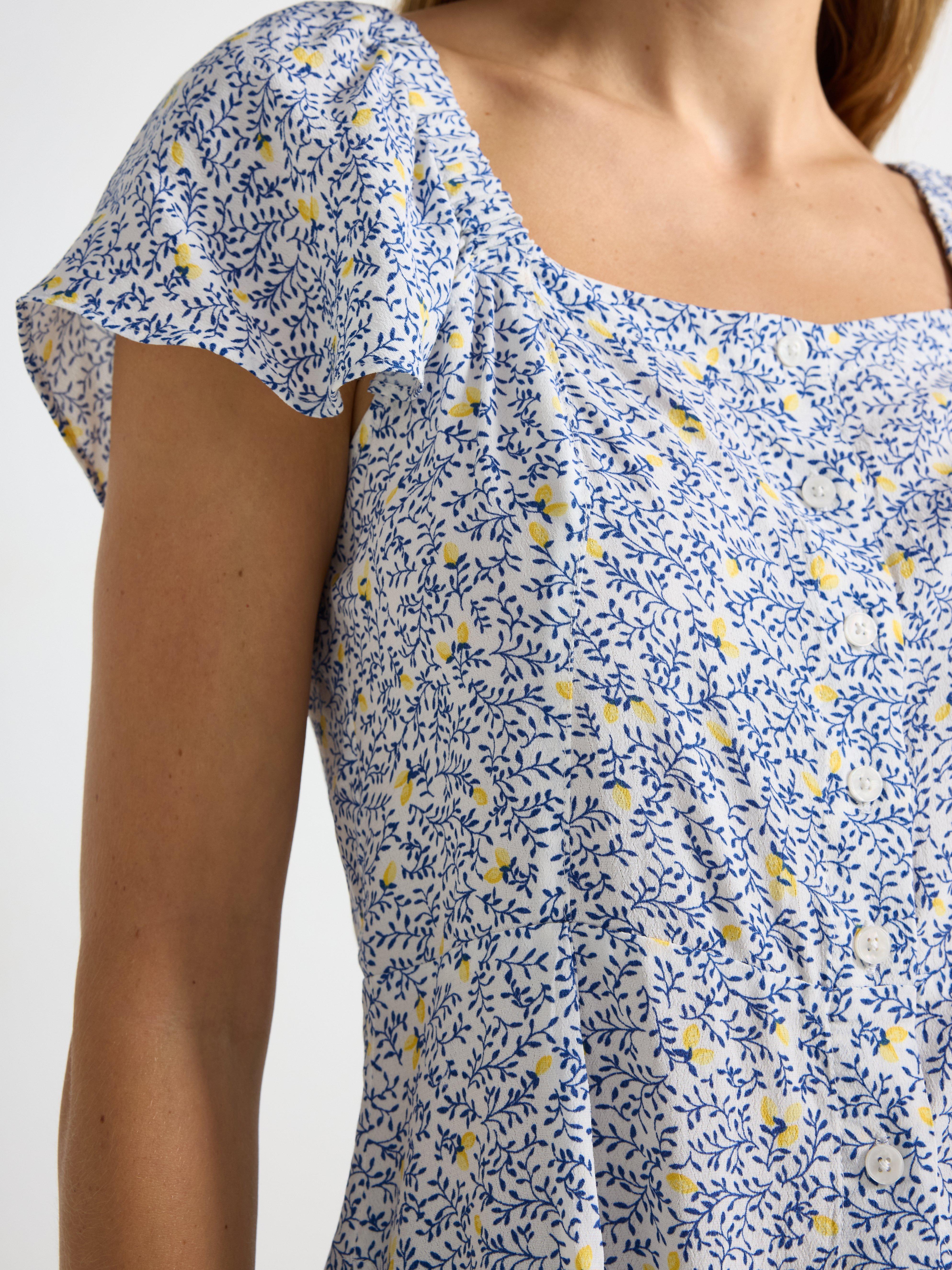 Blusa de manga corta, color blanco empolvado claro.