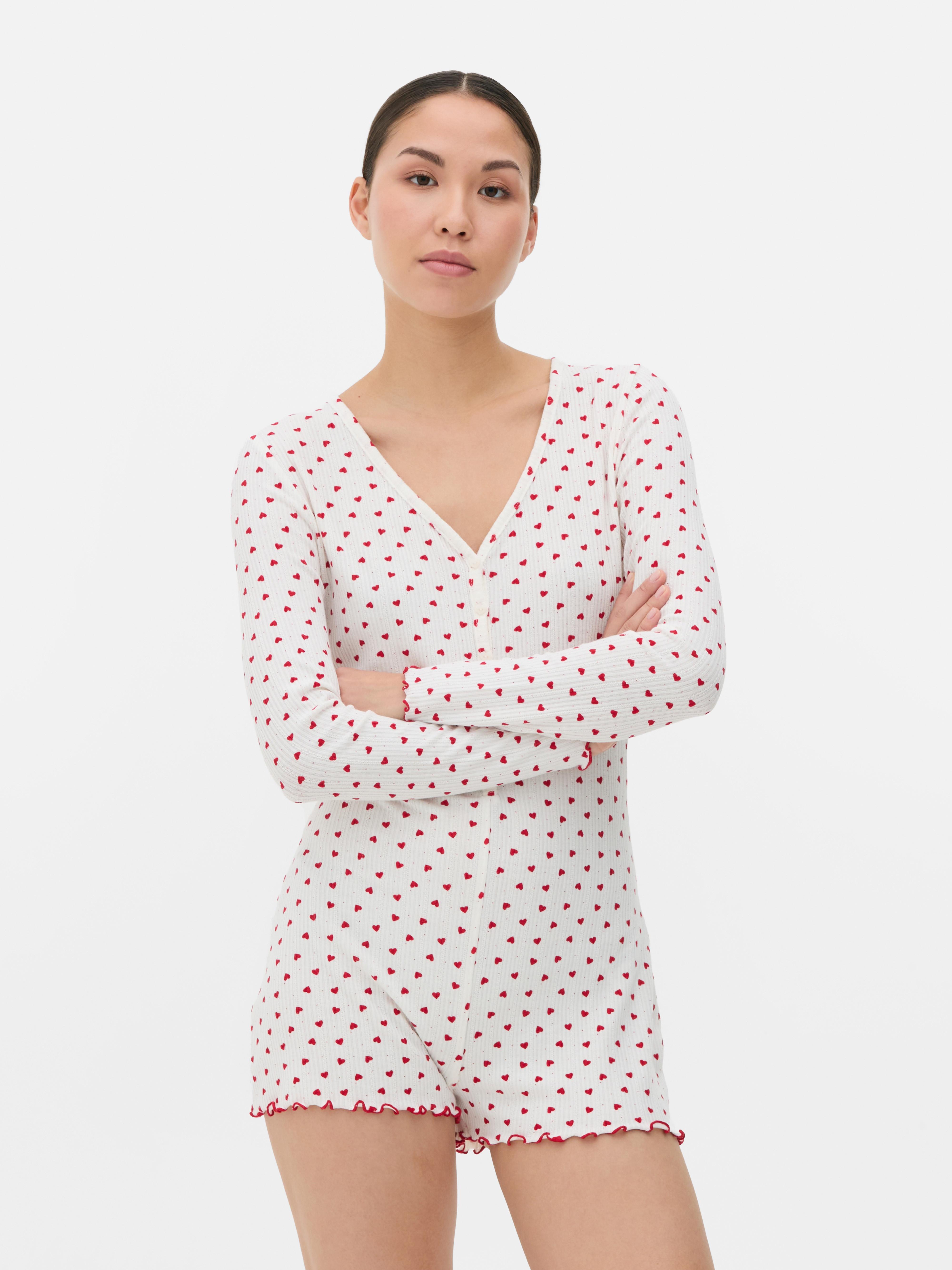 Salopetă de pijama cu model cu inimă. O salopetă de pijama confecționată din material moale cu nervuri, cu tiv festonat și model.