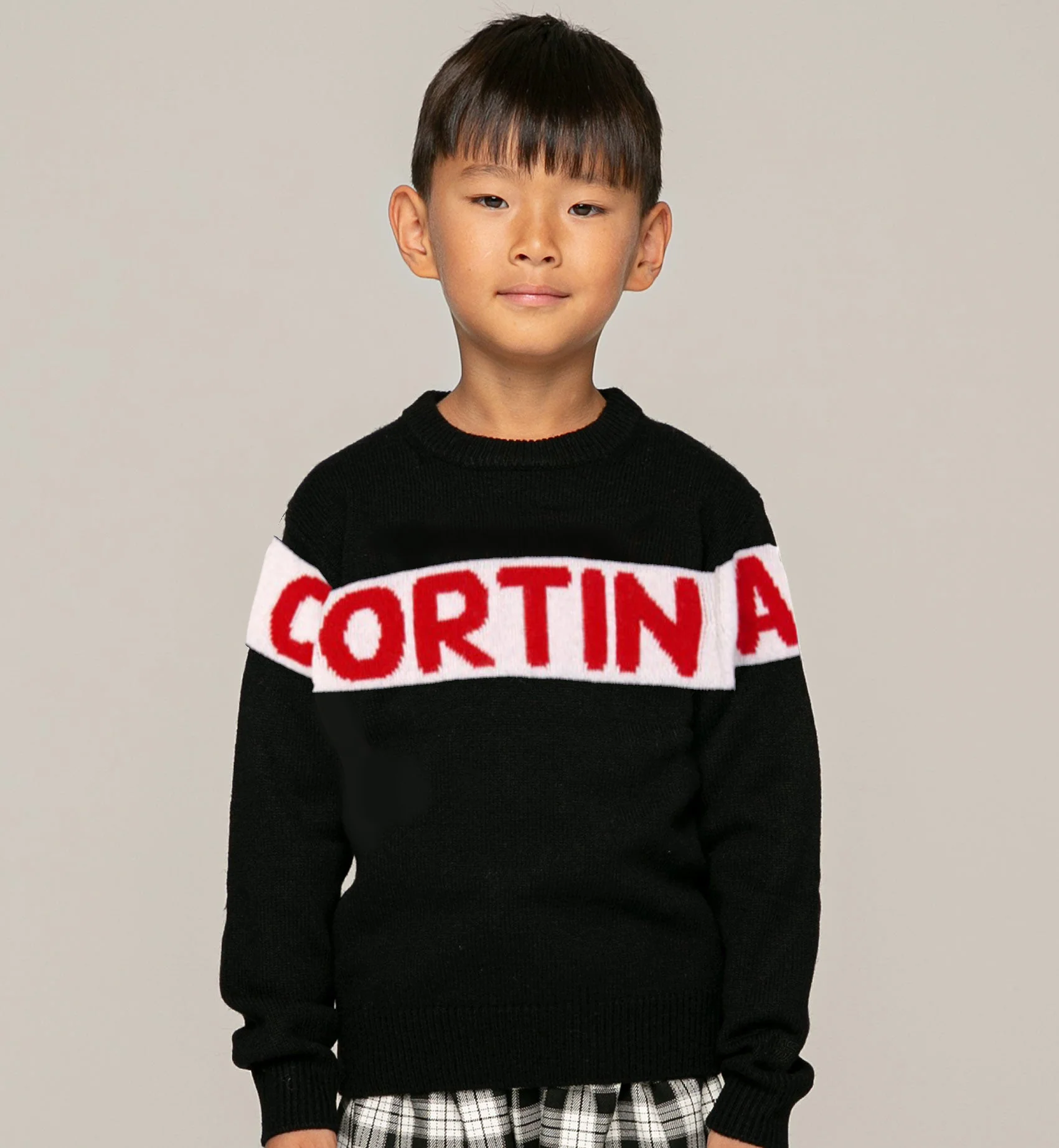 Blauwe trui voor kinderen met rode Cortina-opdruk.