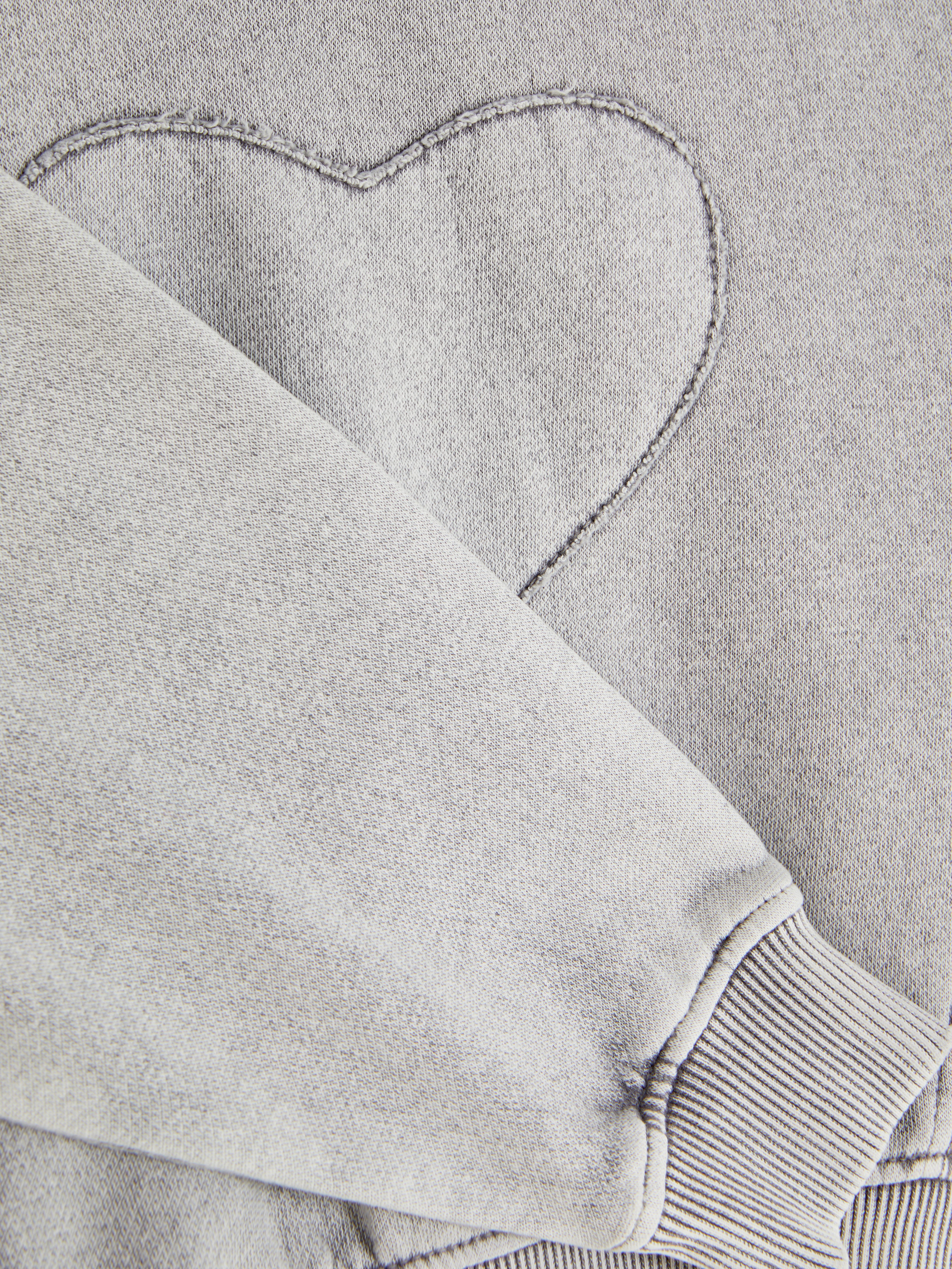 Sweatshirt im Acid-Wash-Stil mit Herzmotiv. Ein Sweatshirt mit Auswasch-Effekt, Herzmotiv und gerippten Bündchen.