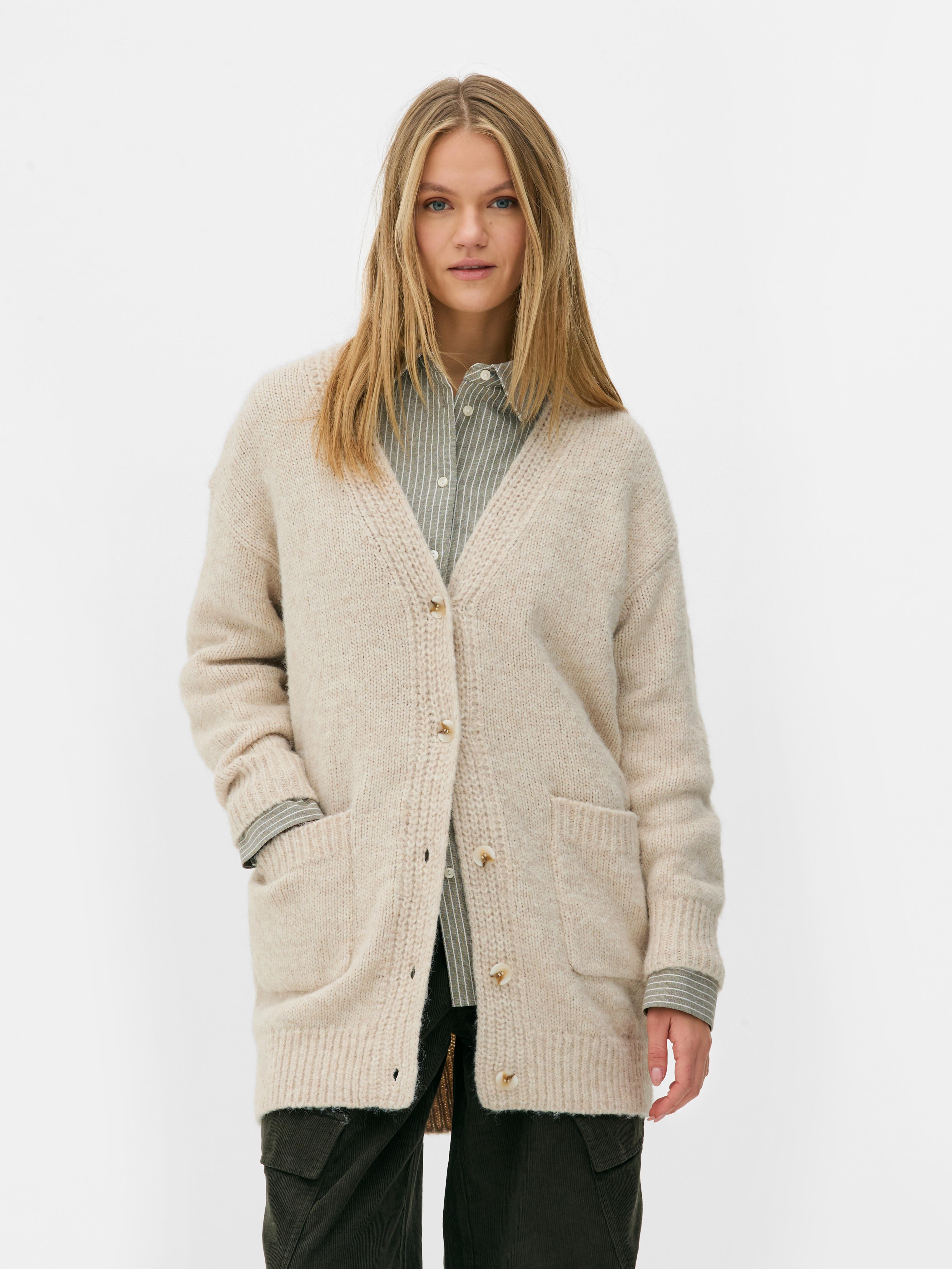 Oversize-Strickjacke. Eine lange Strickjacke mit Oversize-Schnitt, V-Ausschnitt und aufgesetzten Taschen.