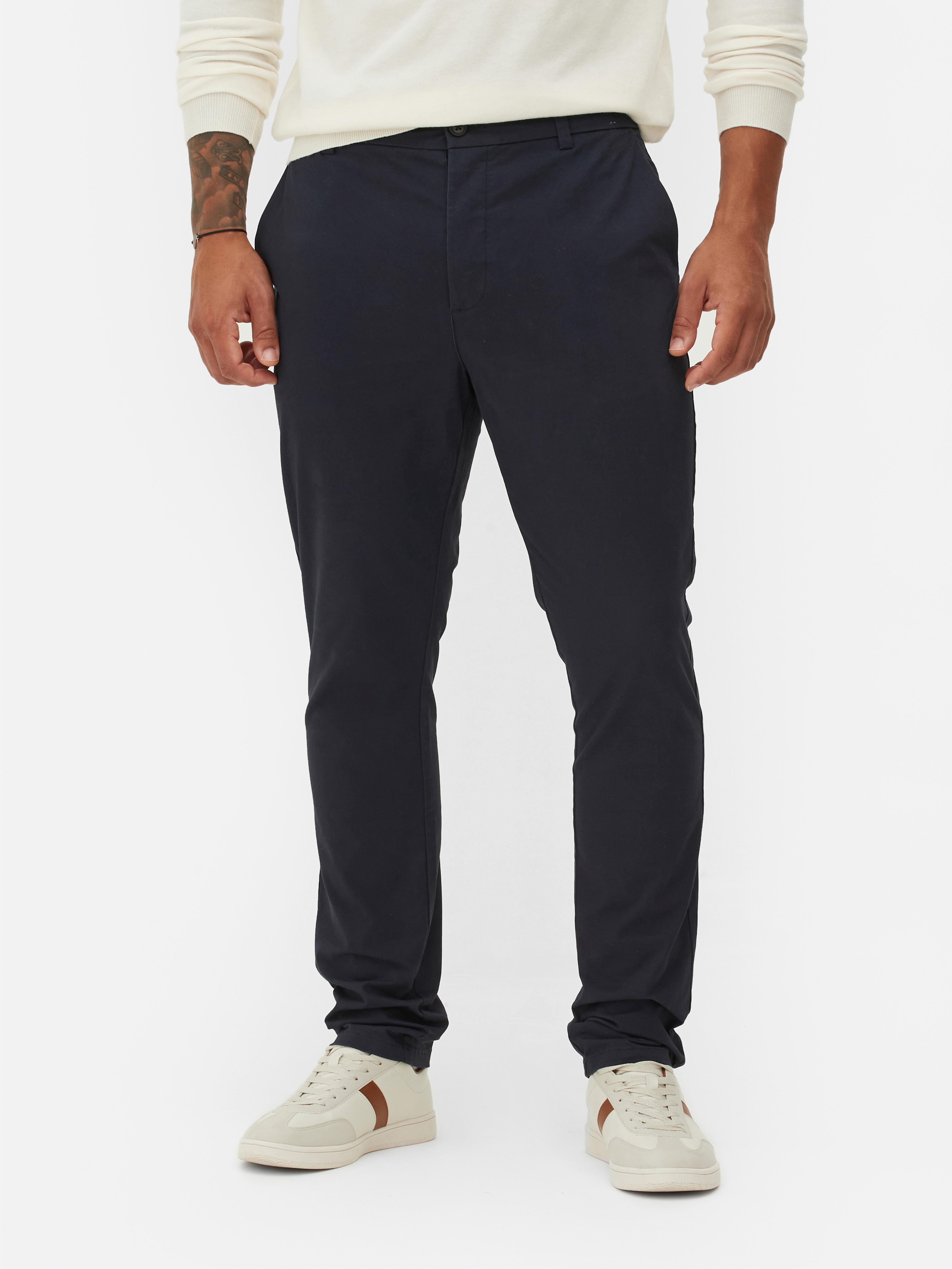 Pantaloni chino elastici, mulați. Pantaloni chino mulați, confecționați în principal din bumbac și cu buzunare laterale.