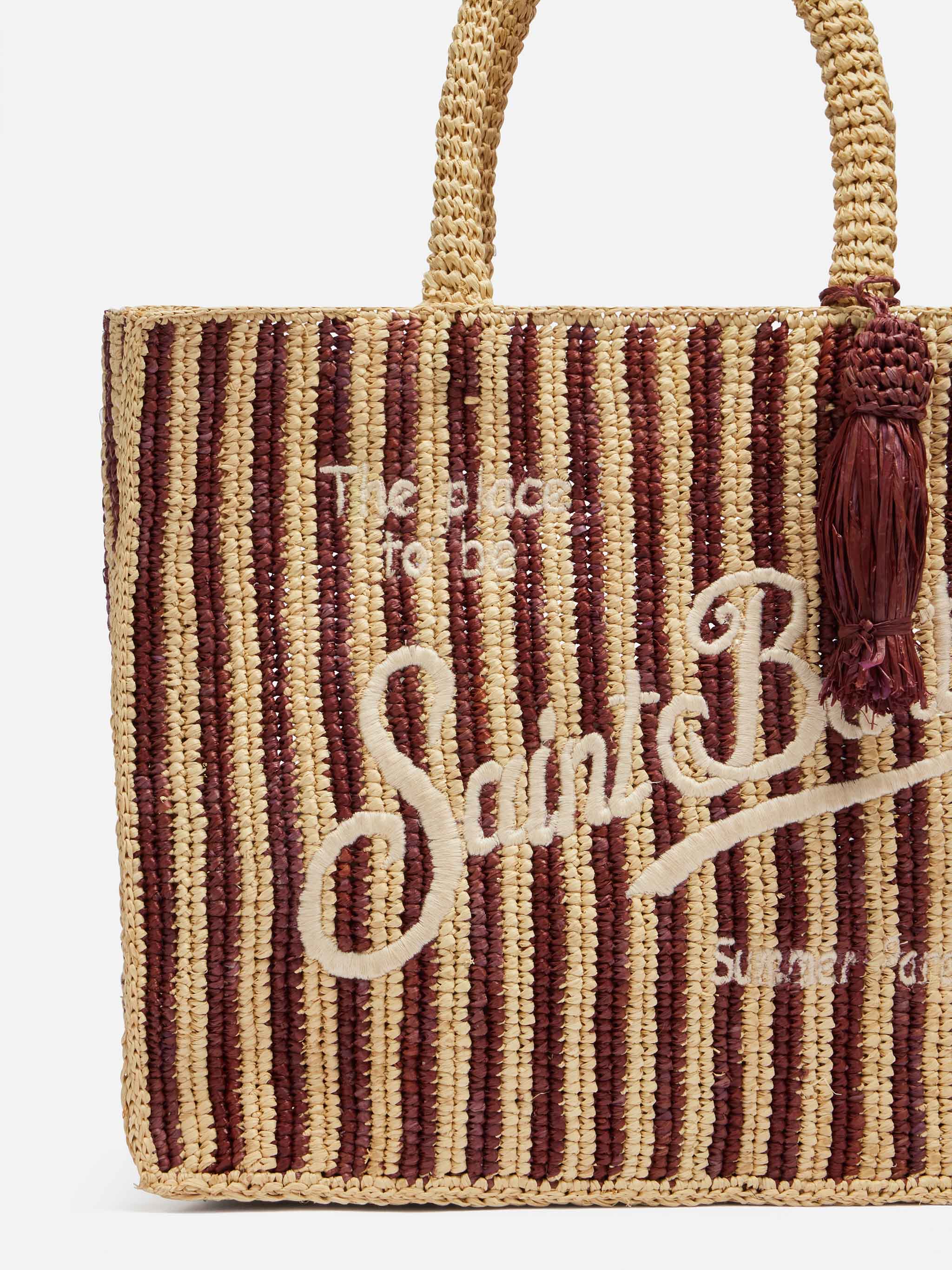Colette tas van bruin gestreept raffia met geborduurd logo.