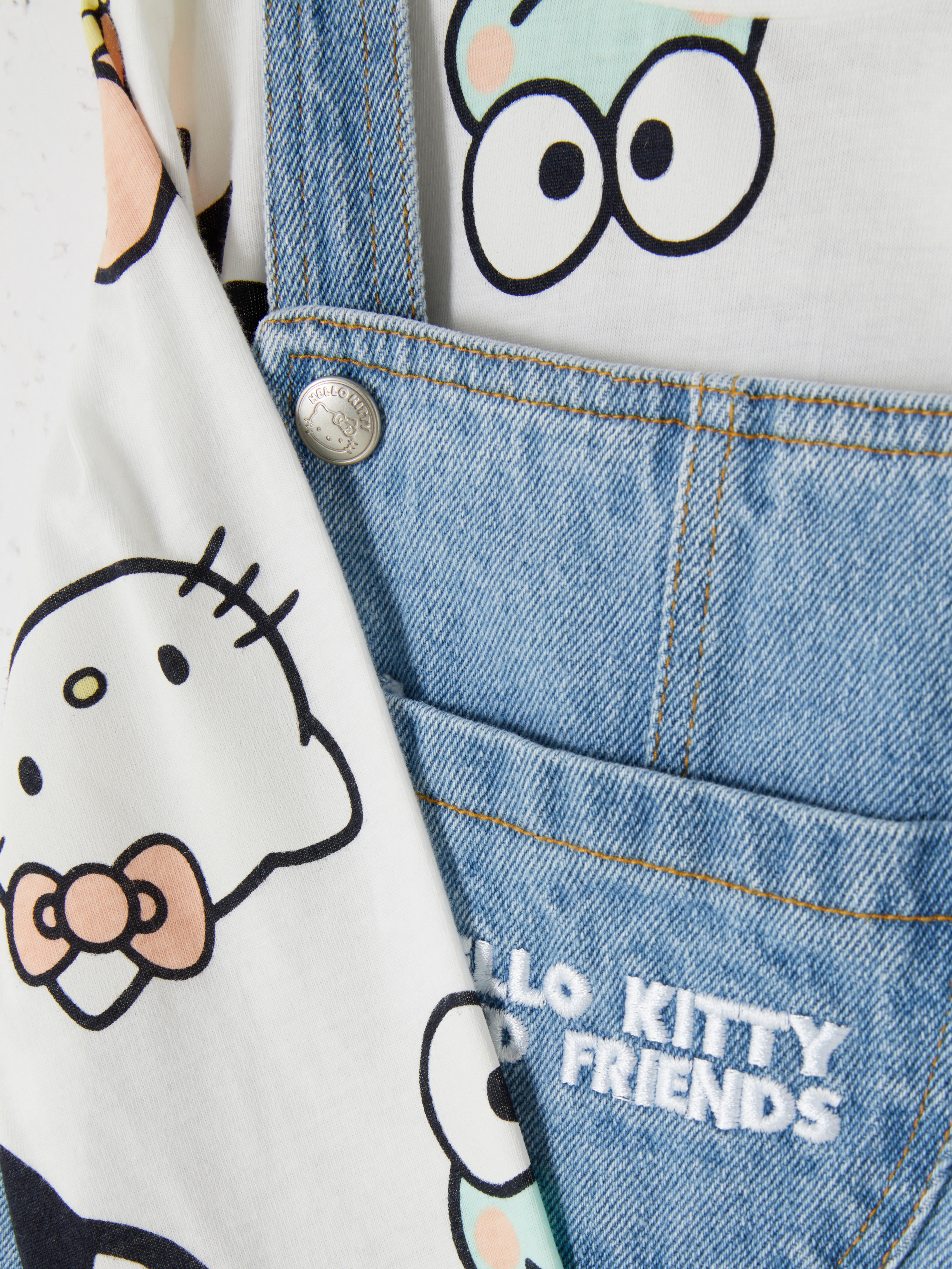 Hello Kitty und ihre Freunde: Schürzenkleid und Langarmshirt. Ein Langarmshirt und ein Jeans-Schürzenkleid mit Hello Kitty und ihren Freunden.