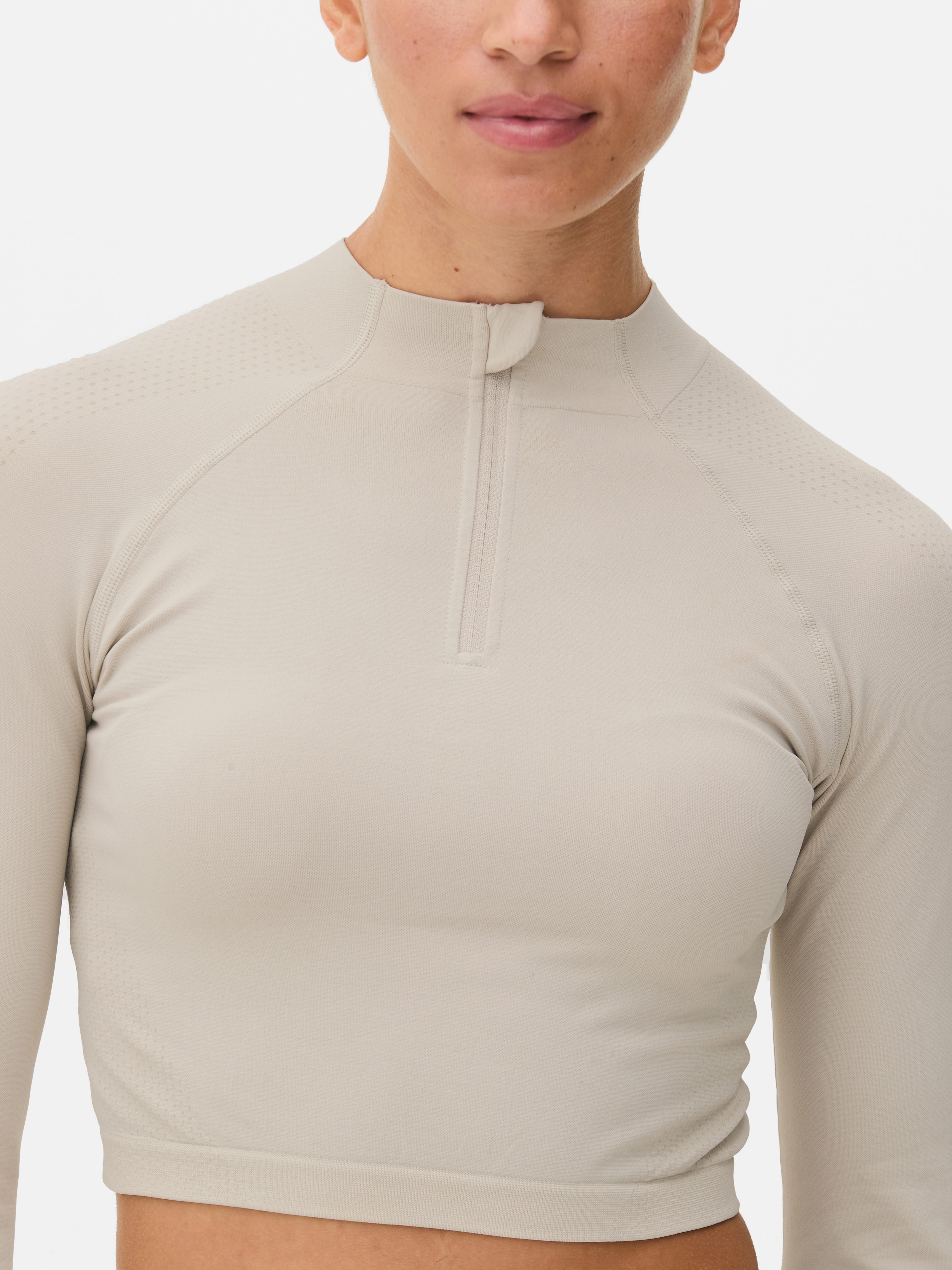 Top sport modelator cu mâneci lungi, fără cusături. Acest top sport scurt, cu fermoar pe jumătate și design fără cusături, este funcțional și elegant.