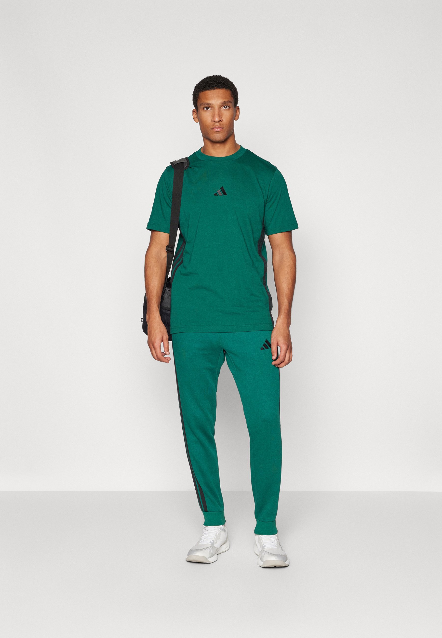 Teplákové nohavice adidas Sportswear - vysokoškolská zelená/čierna