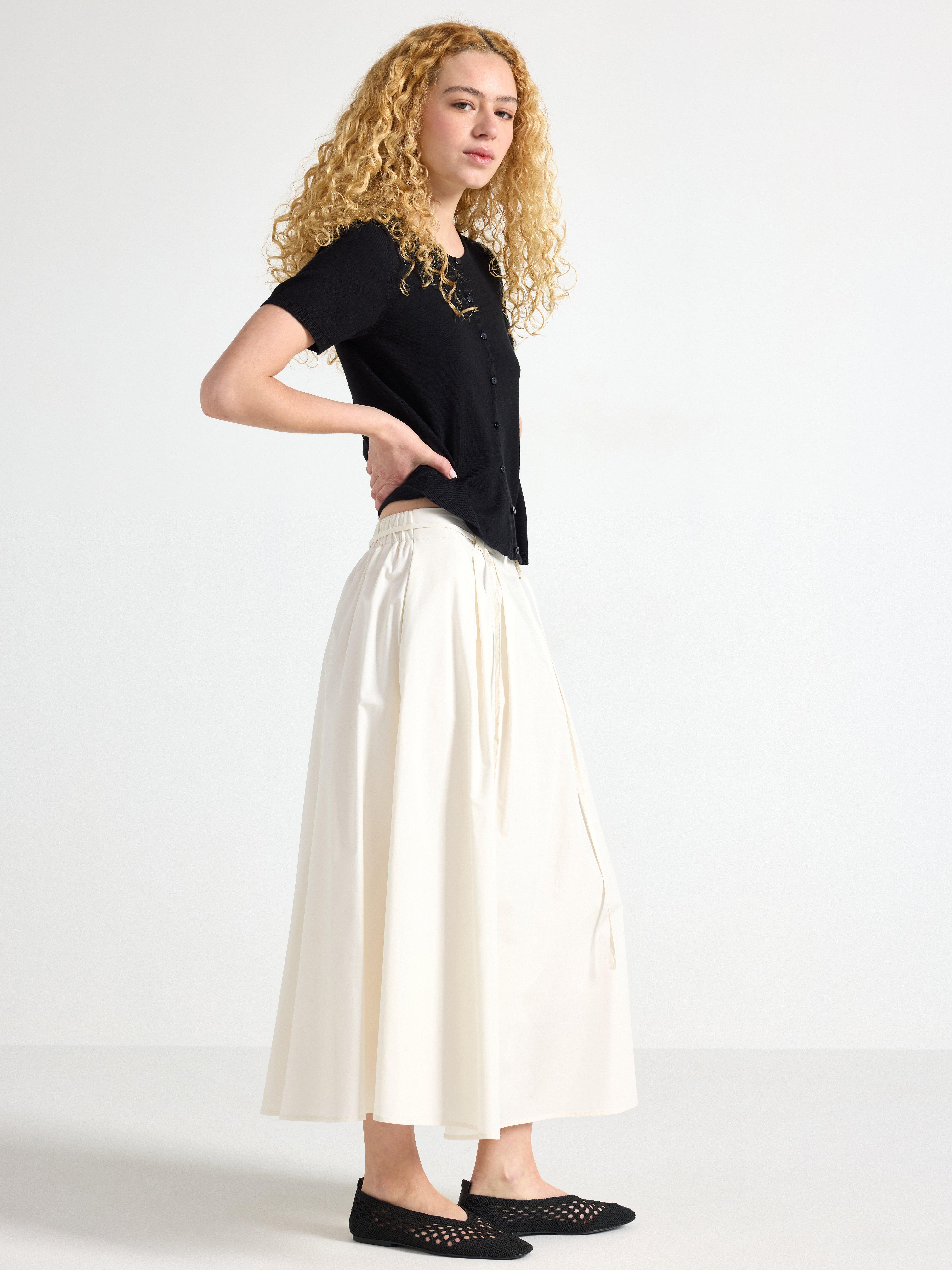 Falda midi plisada, color blanco claro.