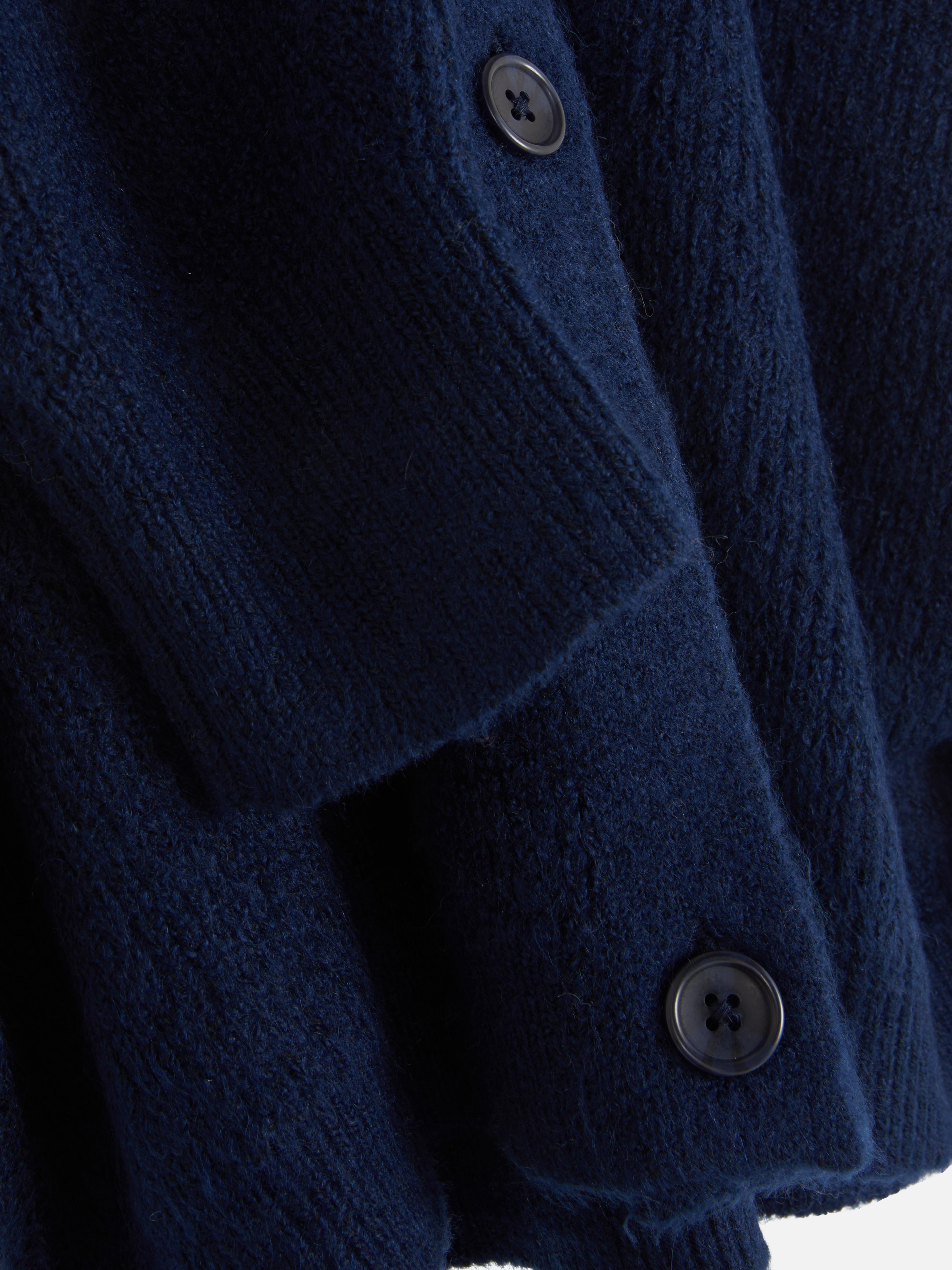 Cardigan cu decolteu în V și croială lejeră. Acest cardigan cu nasturi, croială lejeră și umeri căzuți este un clasic elegant.