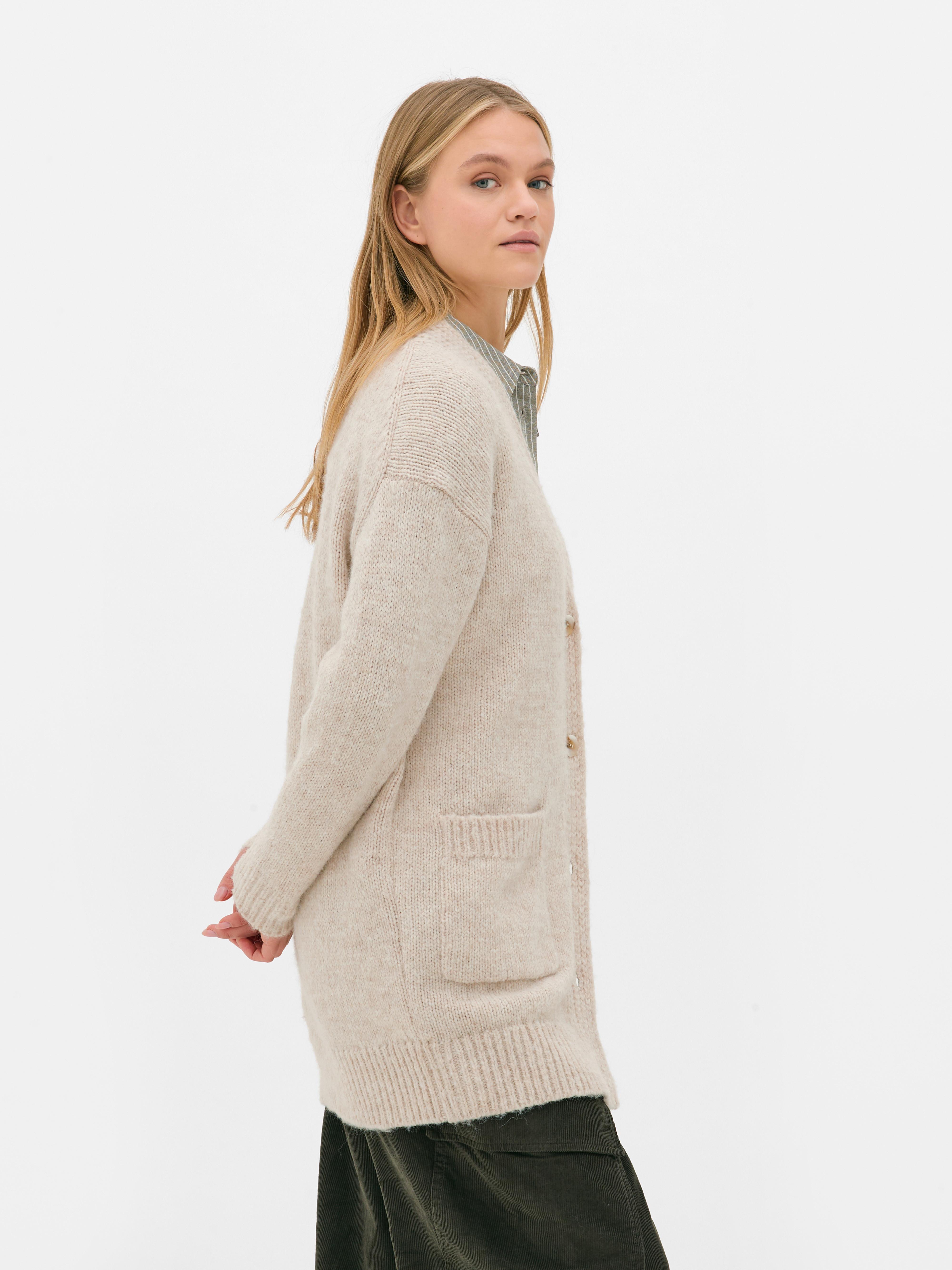 Oversize-Strickjacke. Eine lange Strickjacke mit Oversize-Schnitt, V-Ausschnitt und aufgesetzten Taschen.