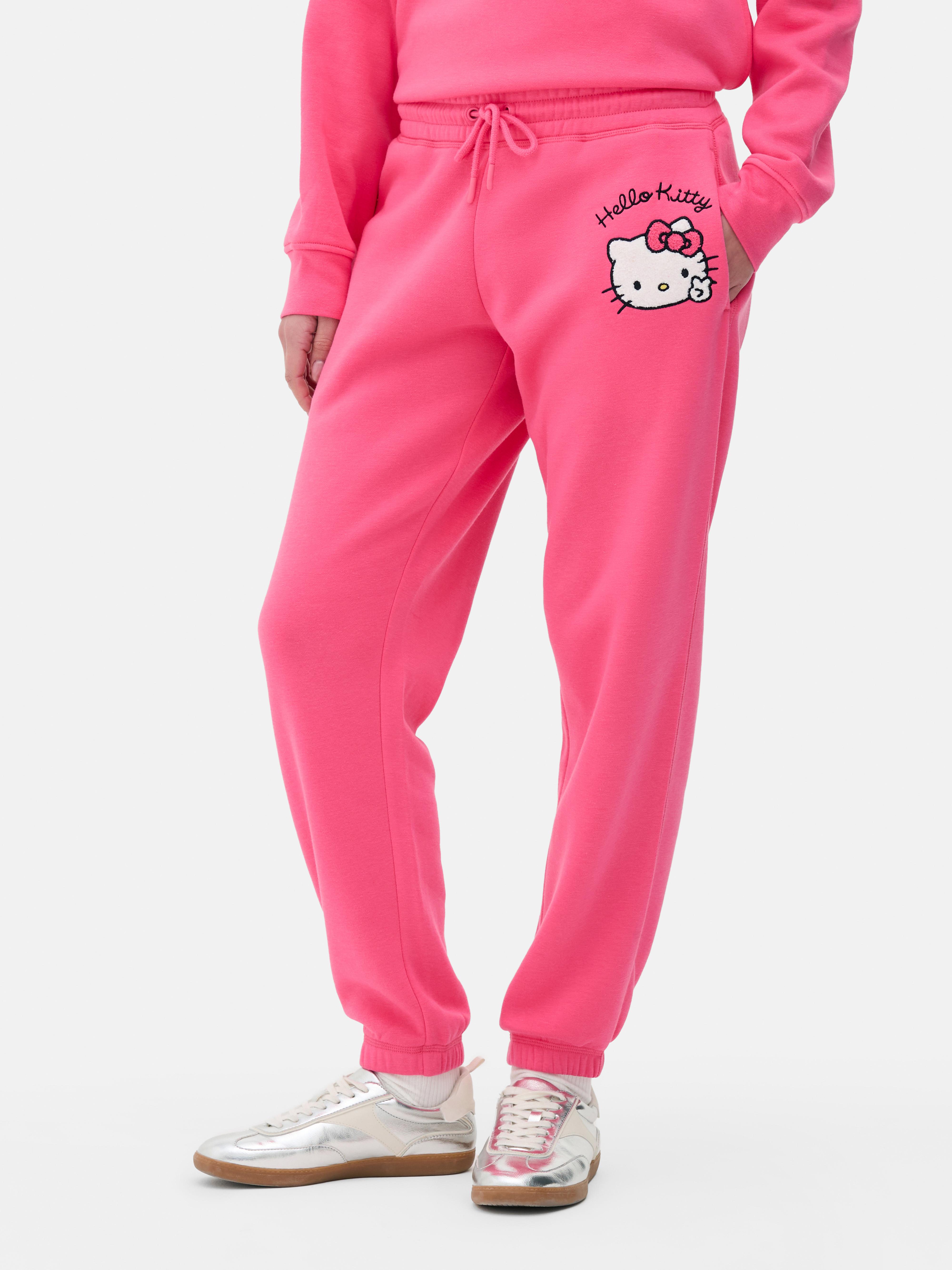 Pantaloni de trening asortați cu etichetă cu logo-ul Hello Kitty. Câștigă puncte kawaii cu acești pantaloni de trening Hello Kitty cu etichetă.