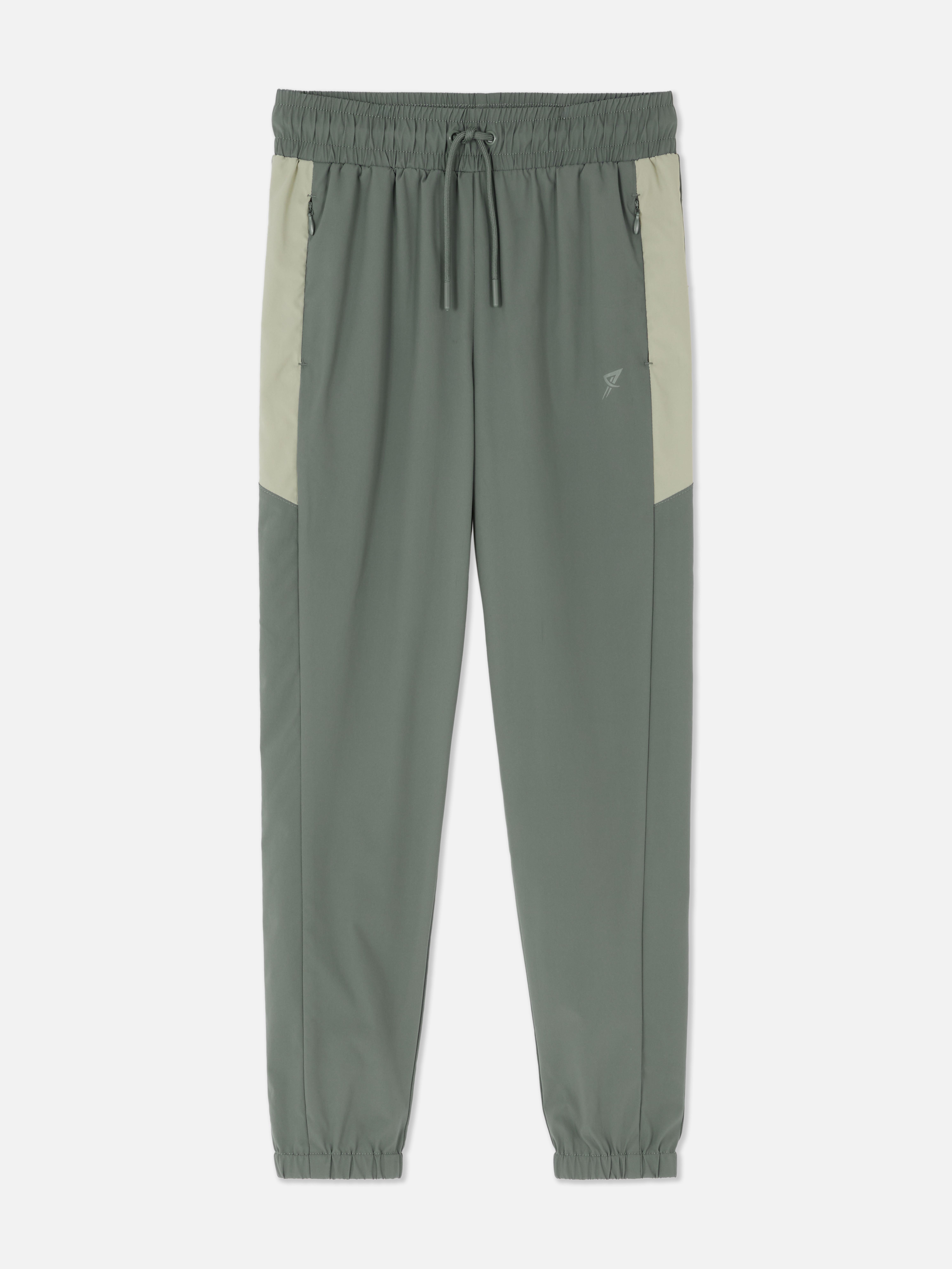 Pantaloni sport de jogging cu talie conică. Pantaloni de jogging cu talie cu șnur, buzunare cu fermoar și manșete la gleznă.