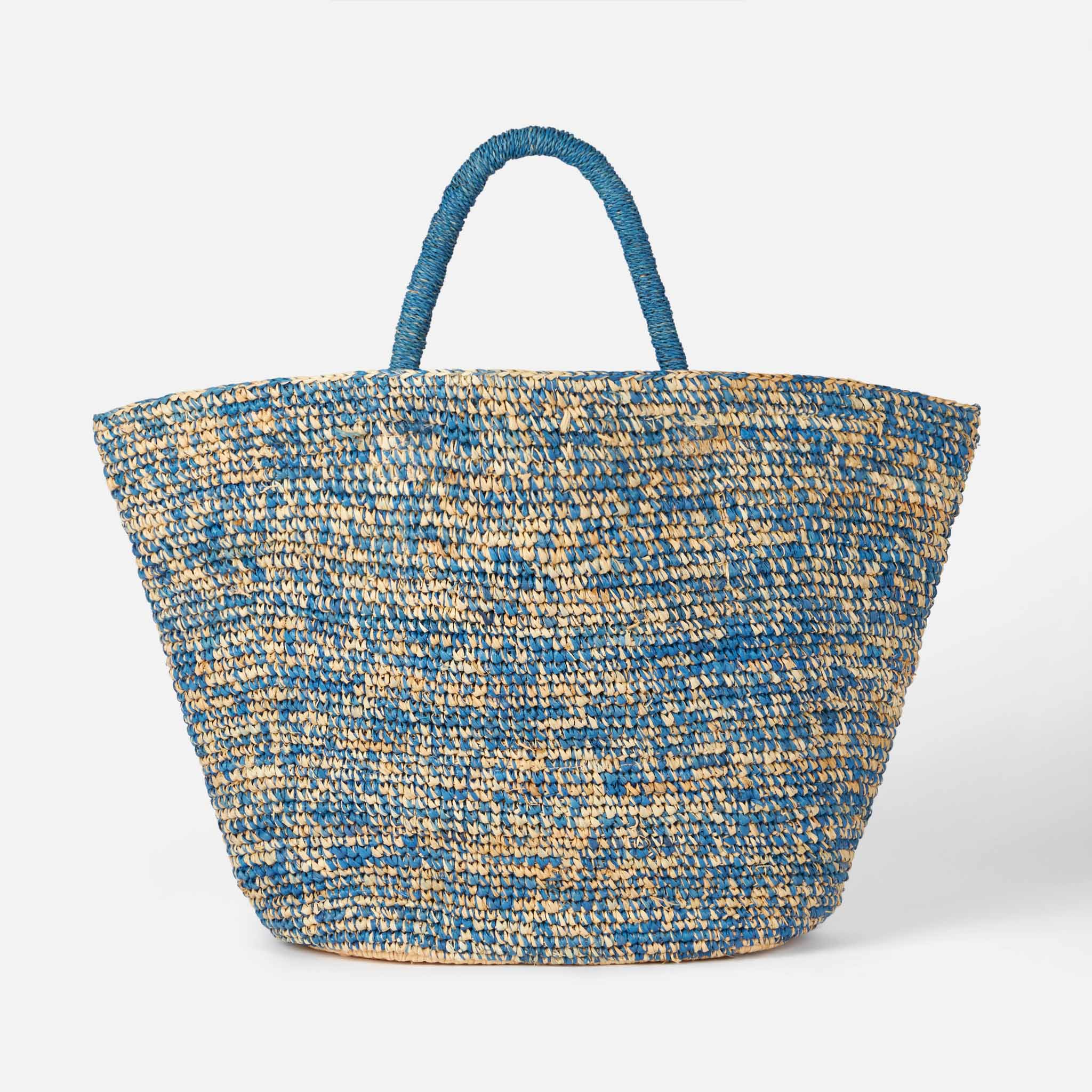 Blauw-witte raffia tas met borduurwerk aan de voorkant.