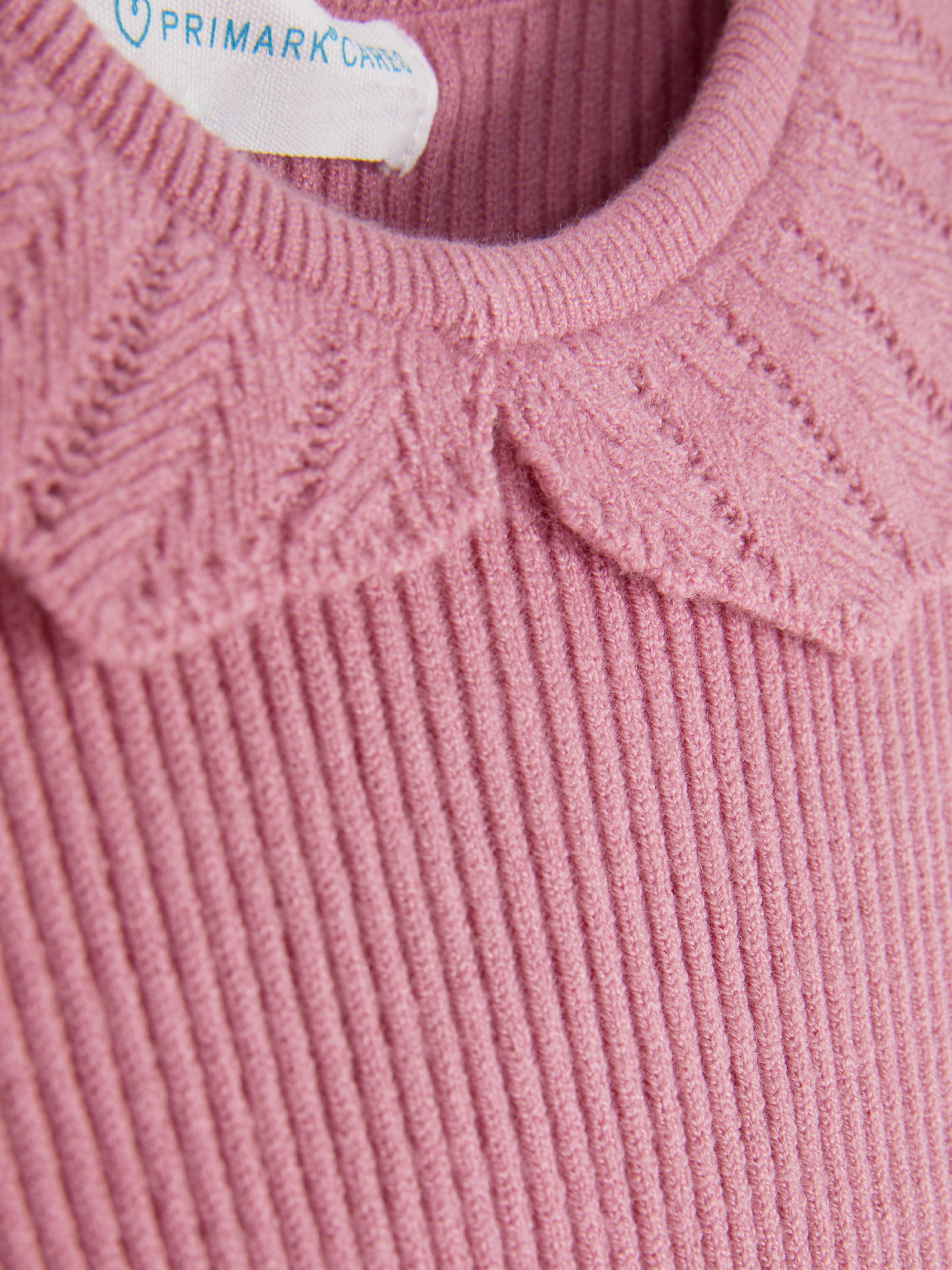 Long-sleeved T-shirt with ruffled collar. This T-shirt has a collar, long sleeves, and a ribbed look.