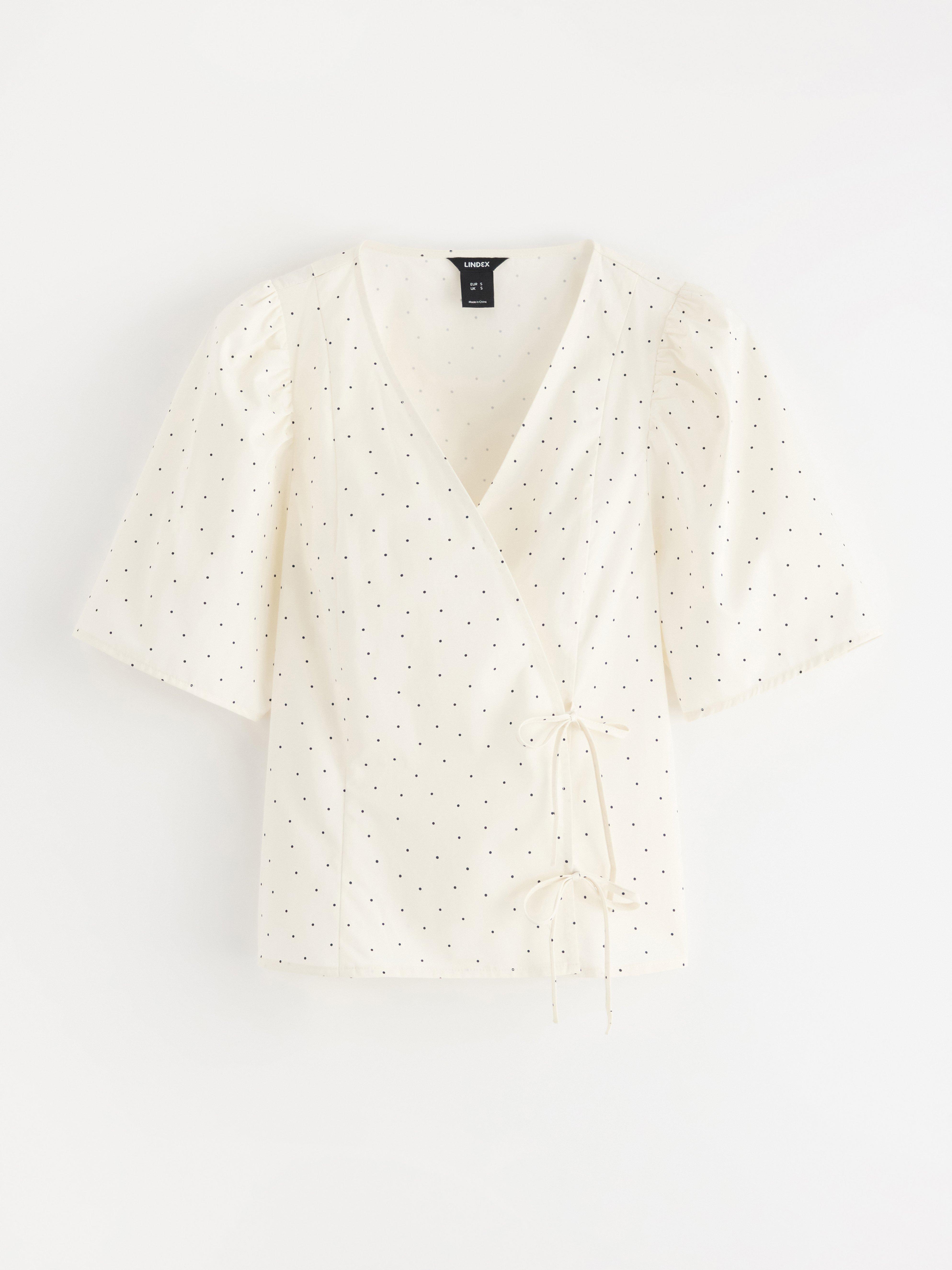 Blusa con diseño cruzado, color blanco claro.