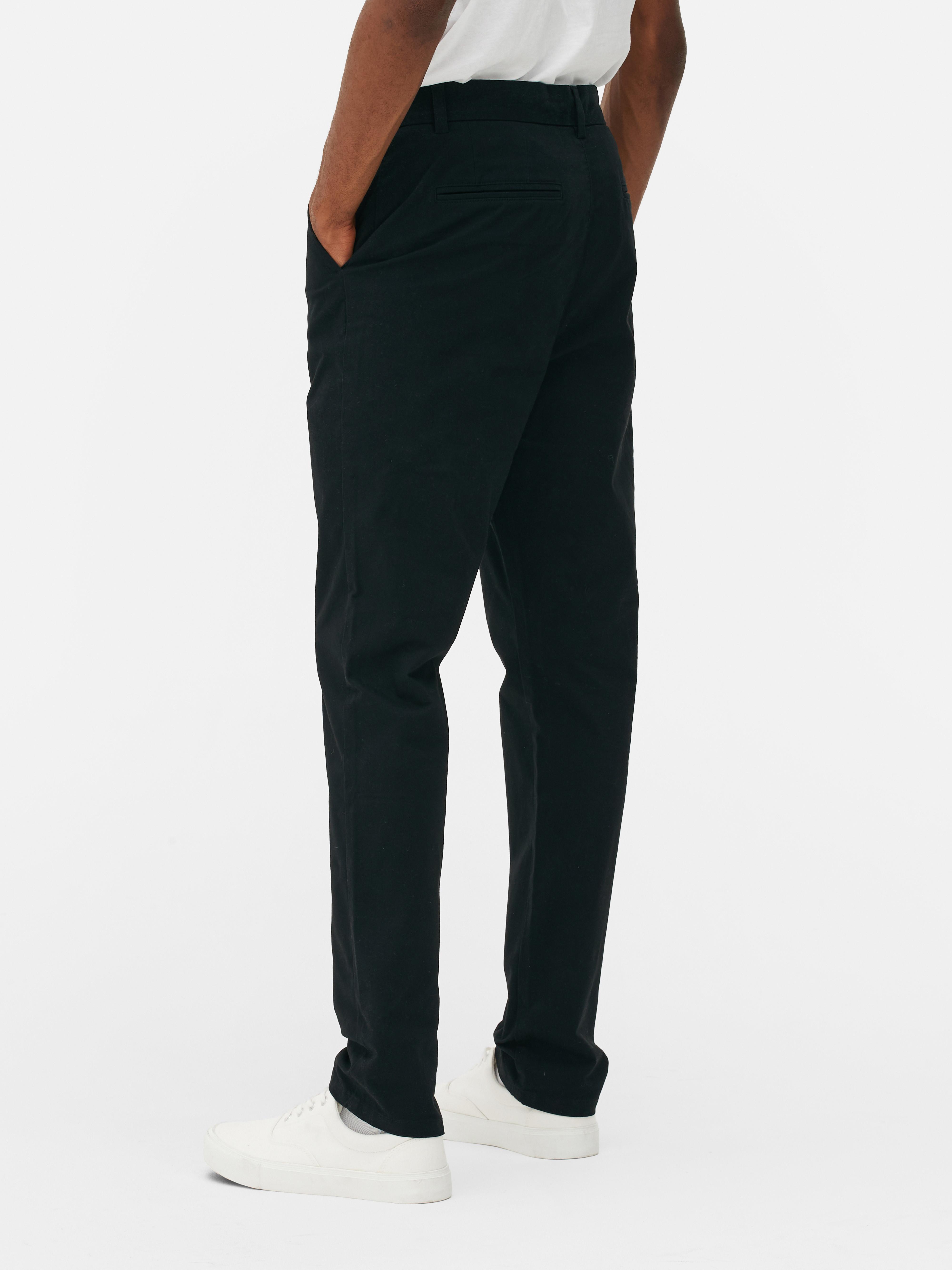 Pantaloni chino elastici, mulați. Pantaloni chino mulați, confecționați în principal din bumbac și cu buzunare laterale.
