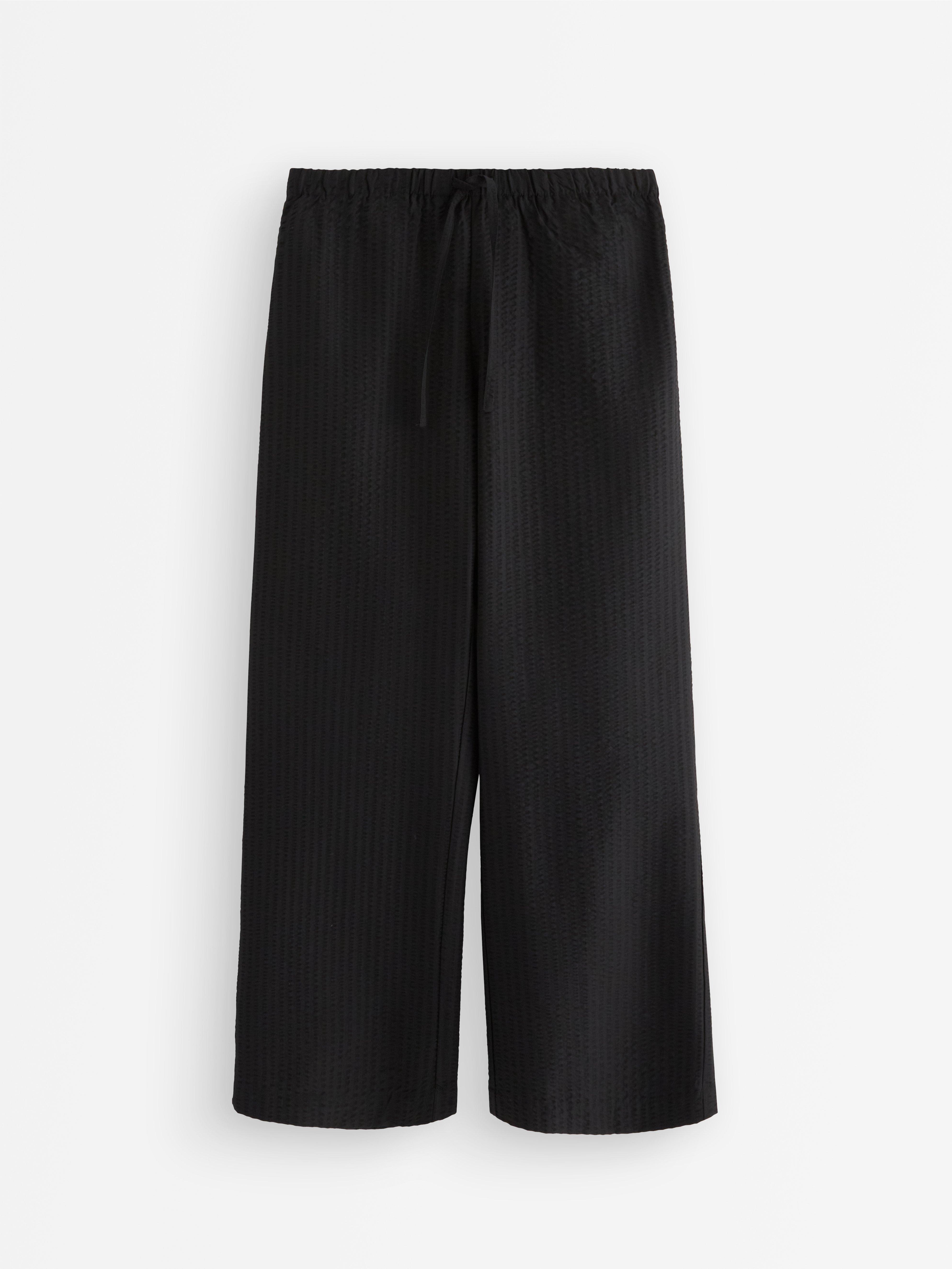 Pantalones rectos acampanados de color negro