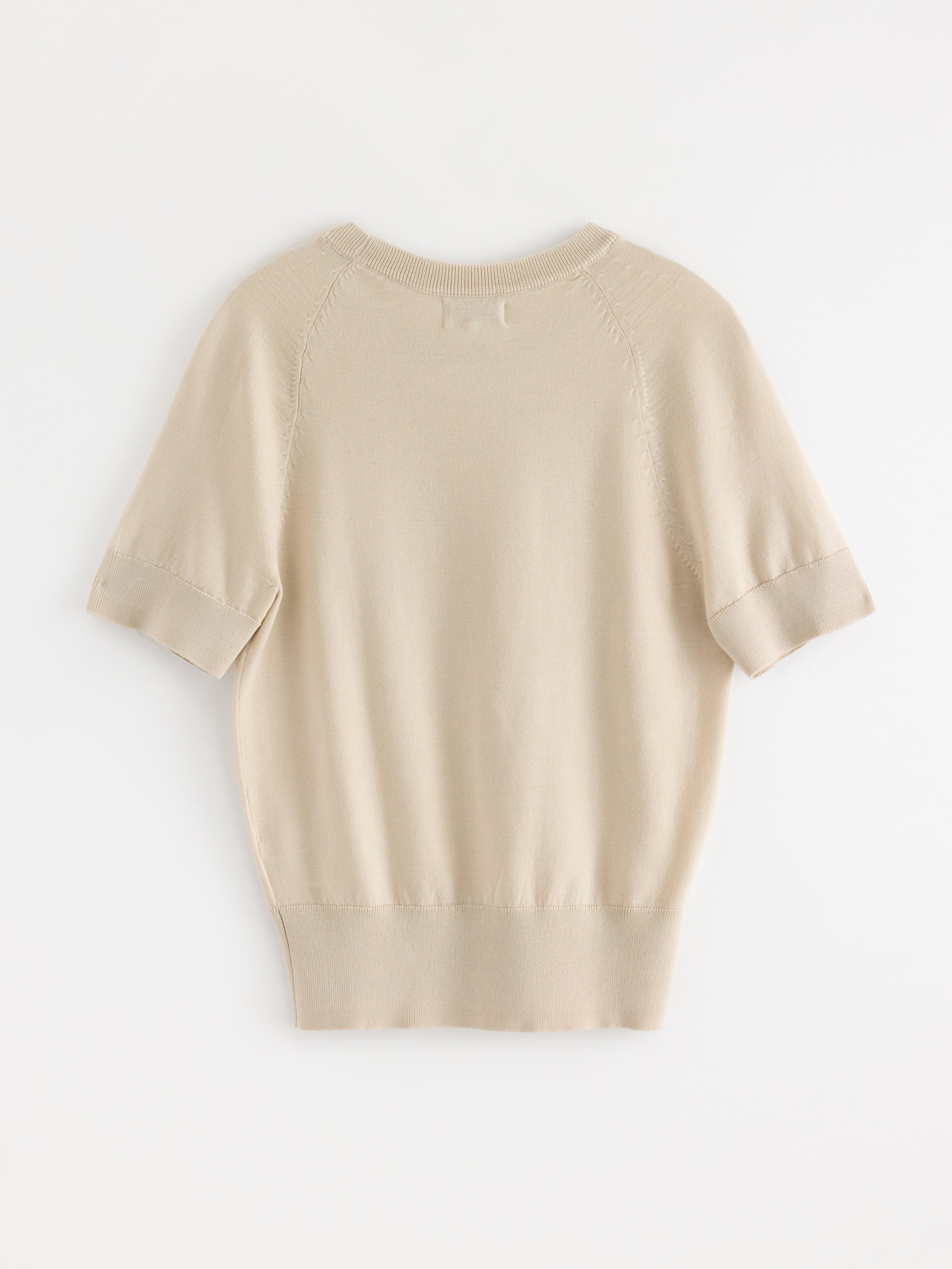 Jersey de punto fino color beige claro.