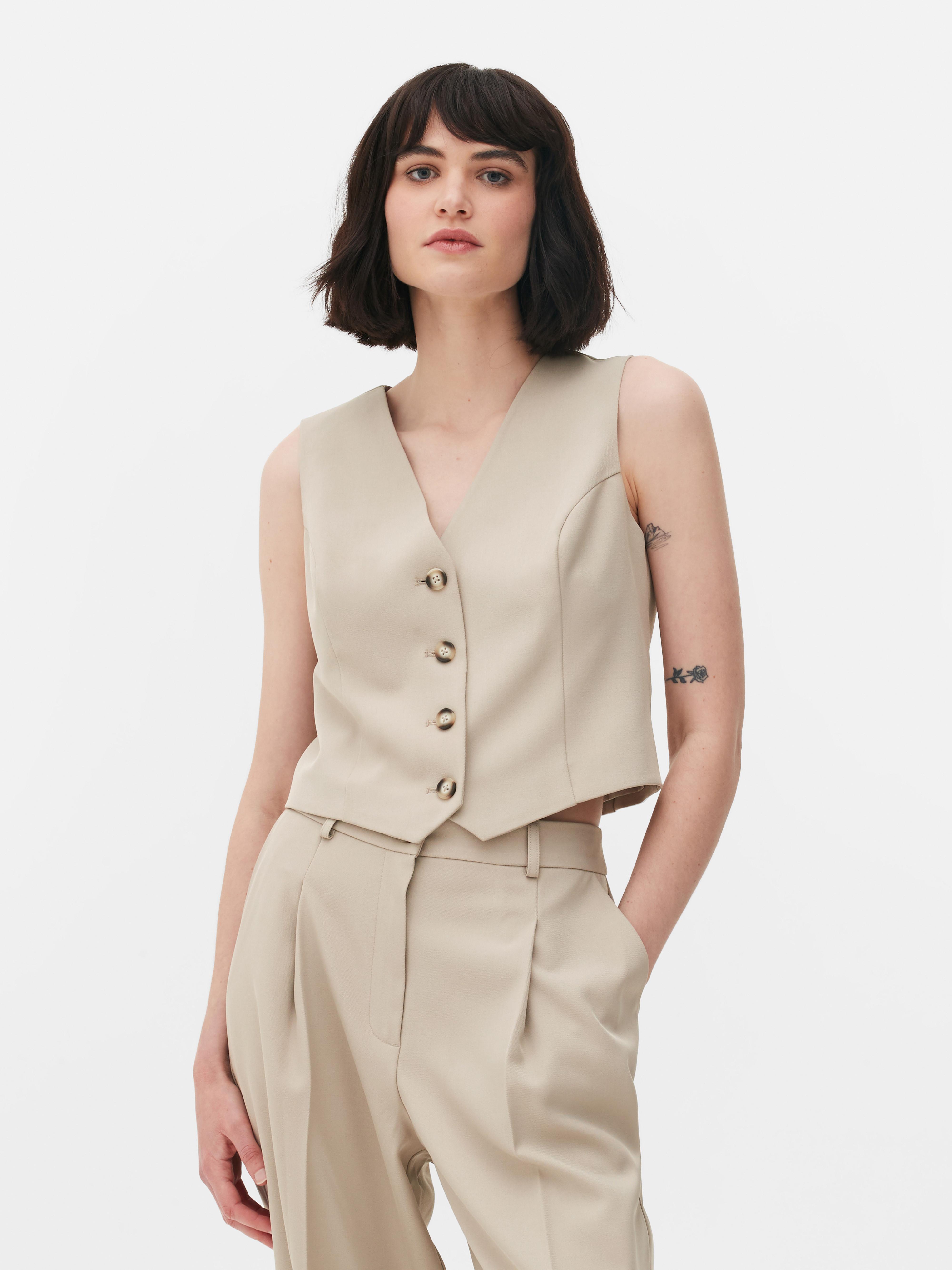 Vestă elegantă cu închidere cu nasturi. Această vestă atemporală, cu cusături prințesă, închidere cu nasturi și decolteu în V, este un adevărat must-have.