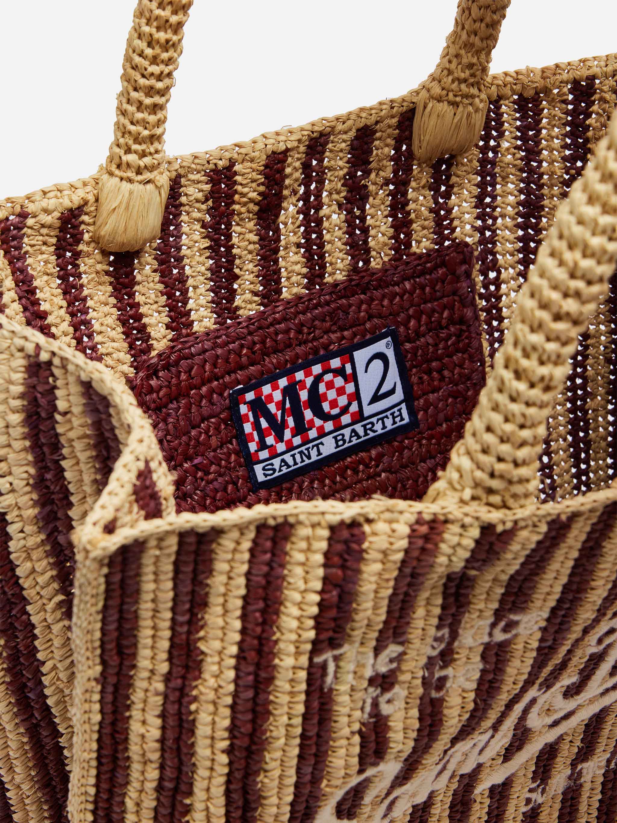 Colette tas van bruin gestreept raffia met geborduurd logo.