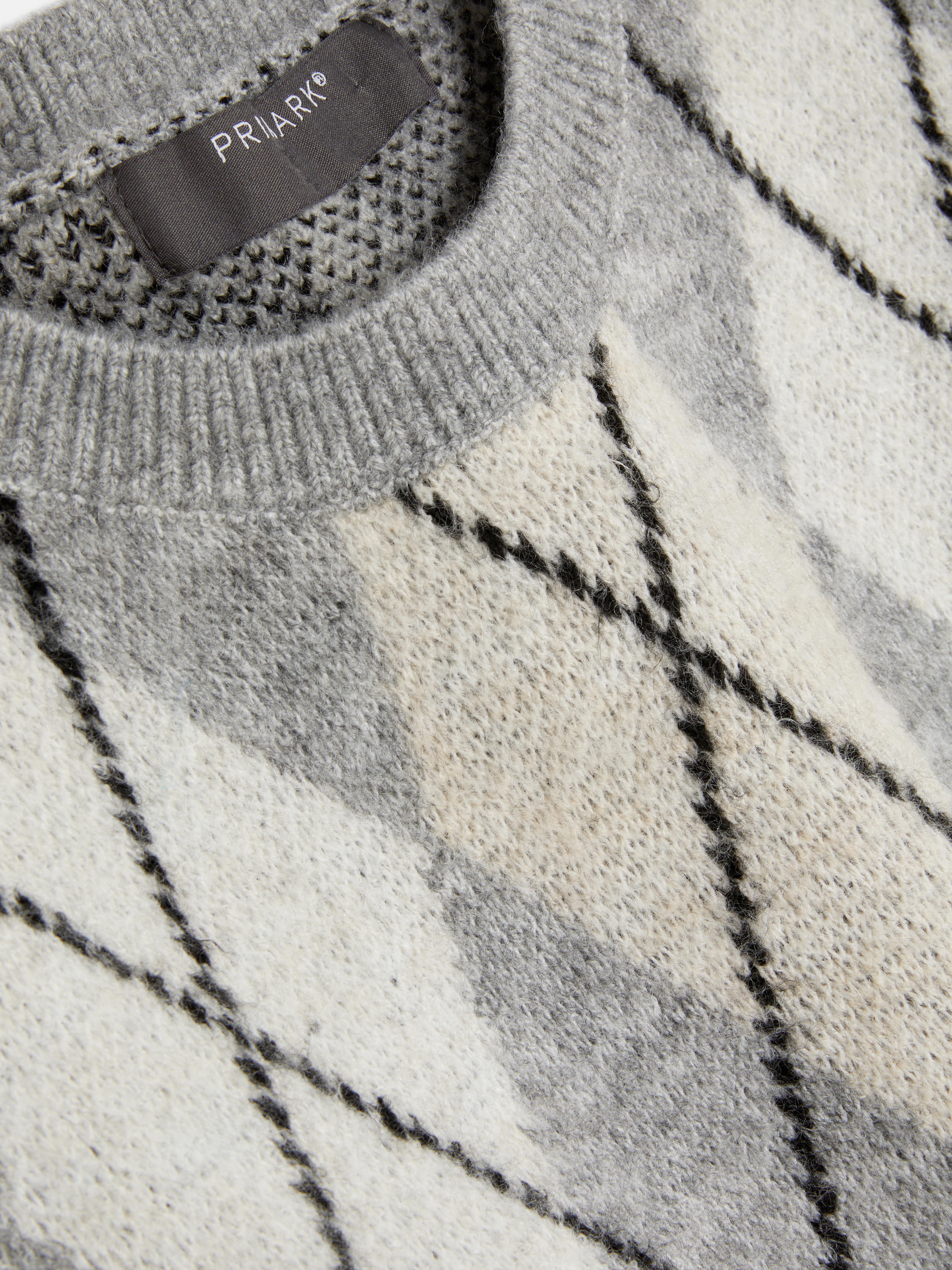 Dzianinowy sweter bez rękawów ze wzorem w romby. Sweter bez rękawów ze ściągaczami przy mankietach i klasycznym wzorem w romby.