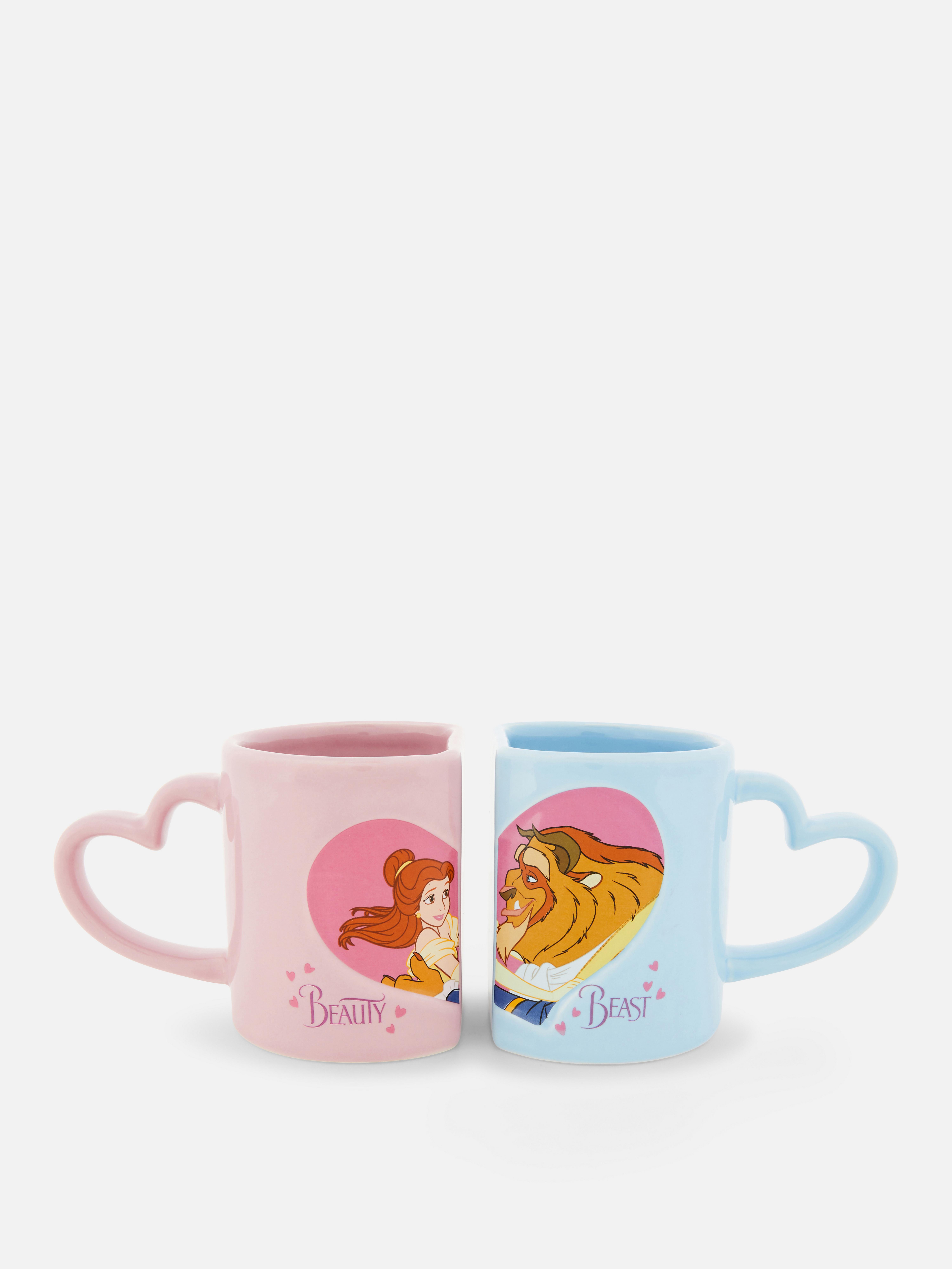 Căni Disney Frumoasa și Bestia cu mânere, set de 2. Două căni Frumoasa și Bestia cu mânere în formă de inimă, livrate într-o cutie cadou.