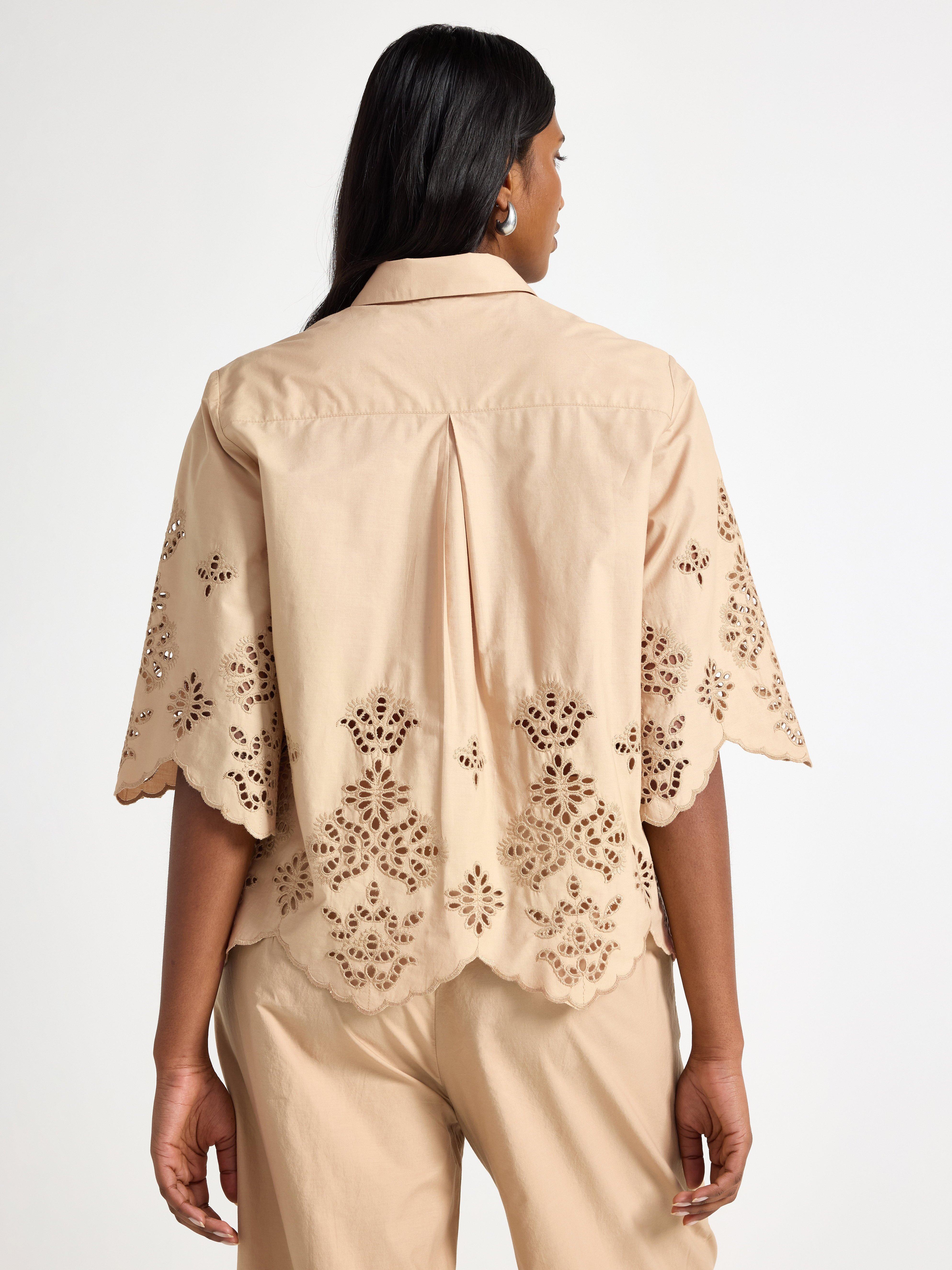 Camisa de manga curta bege com bordado.