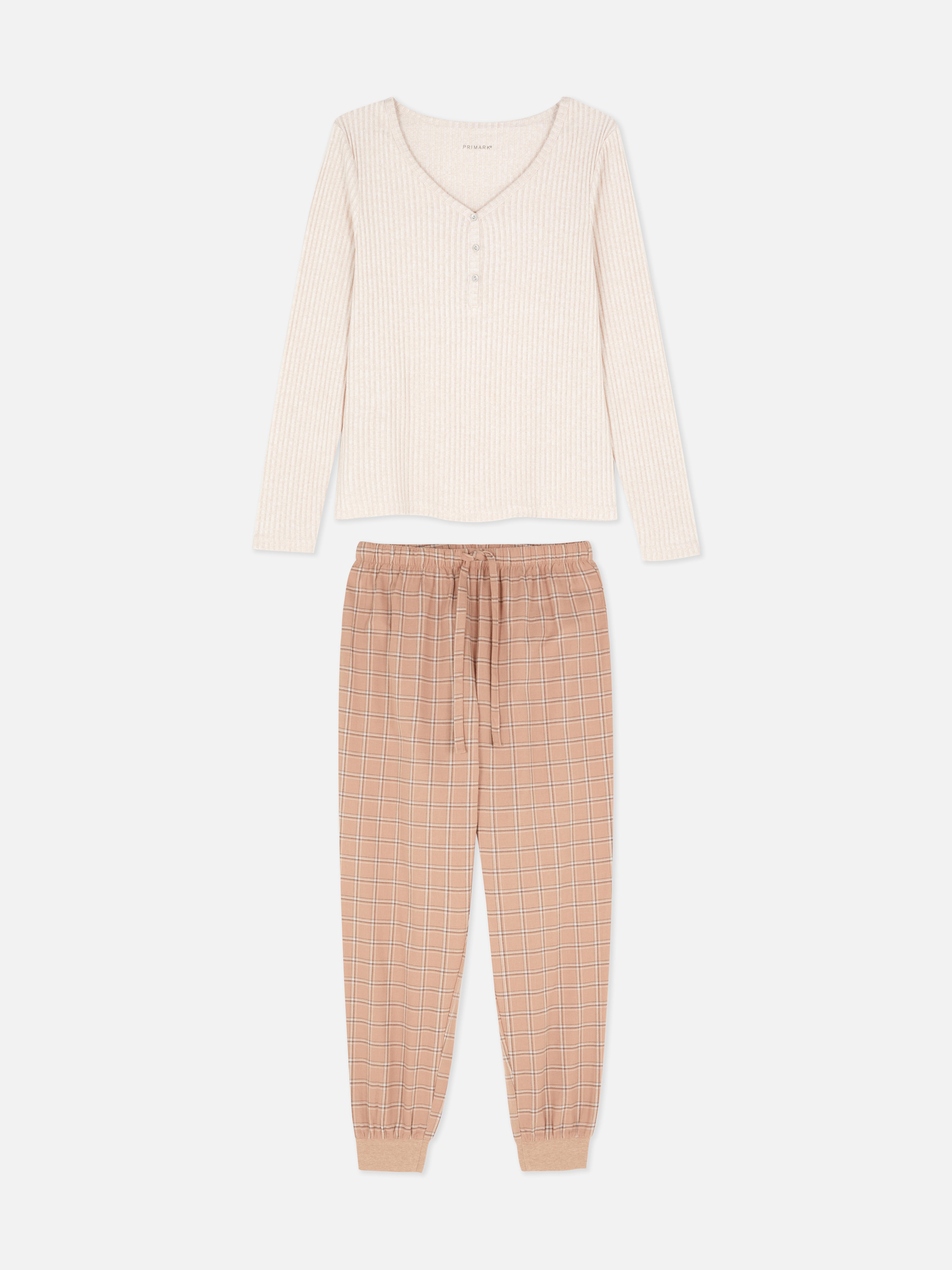Pijamale cu pantaloni în carouri și o cămașă cu mânecă lungă. Aceste pijamale drăguțe și confortabile creează o atmosferă relaxantă.